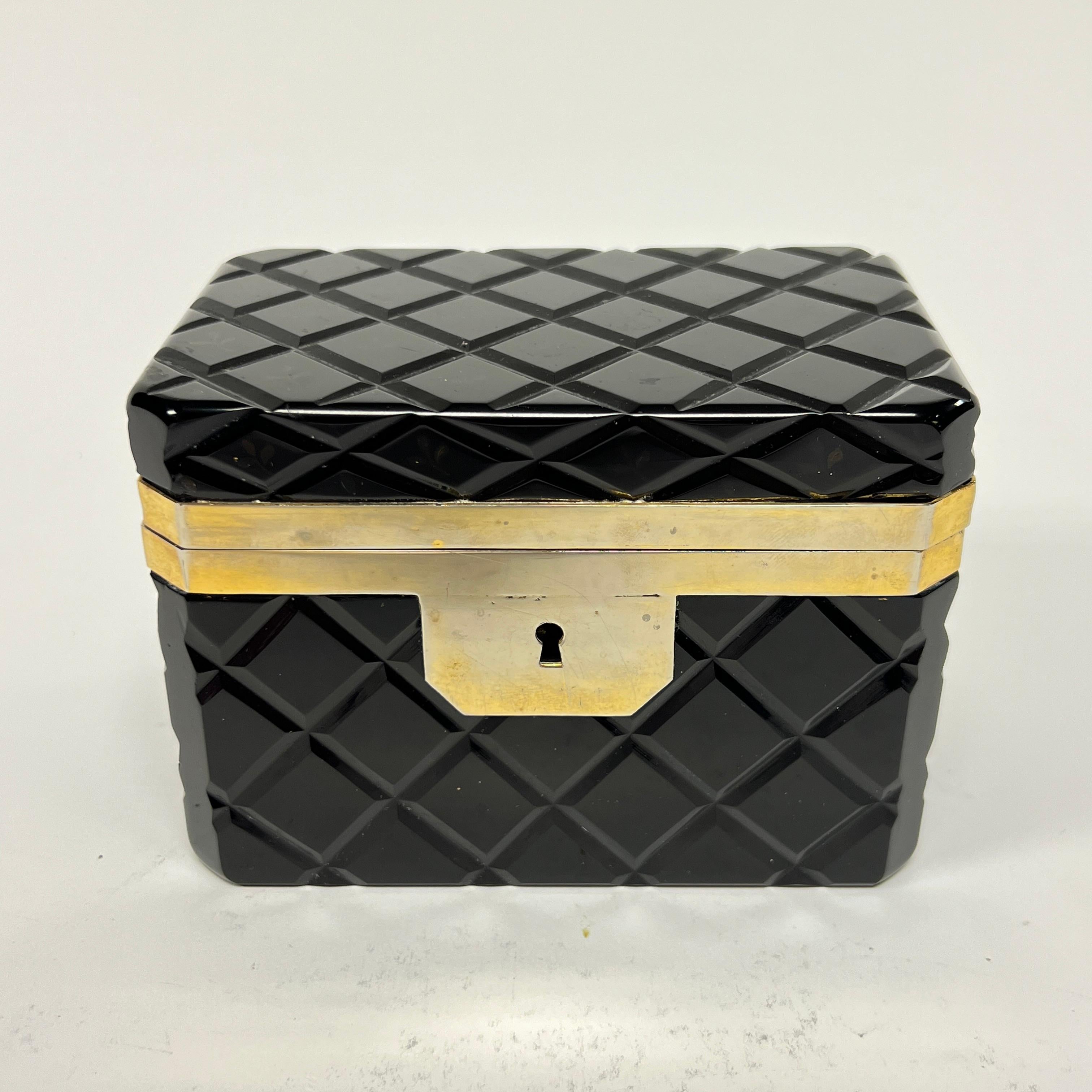 Bonito cofre antiguo (siglo XIX) para joyas o baratijas, de cristal amatista negro con diseño de corte en cruz y monturas de metal dorado.  Aparentemente sin firmar.