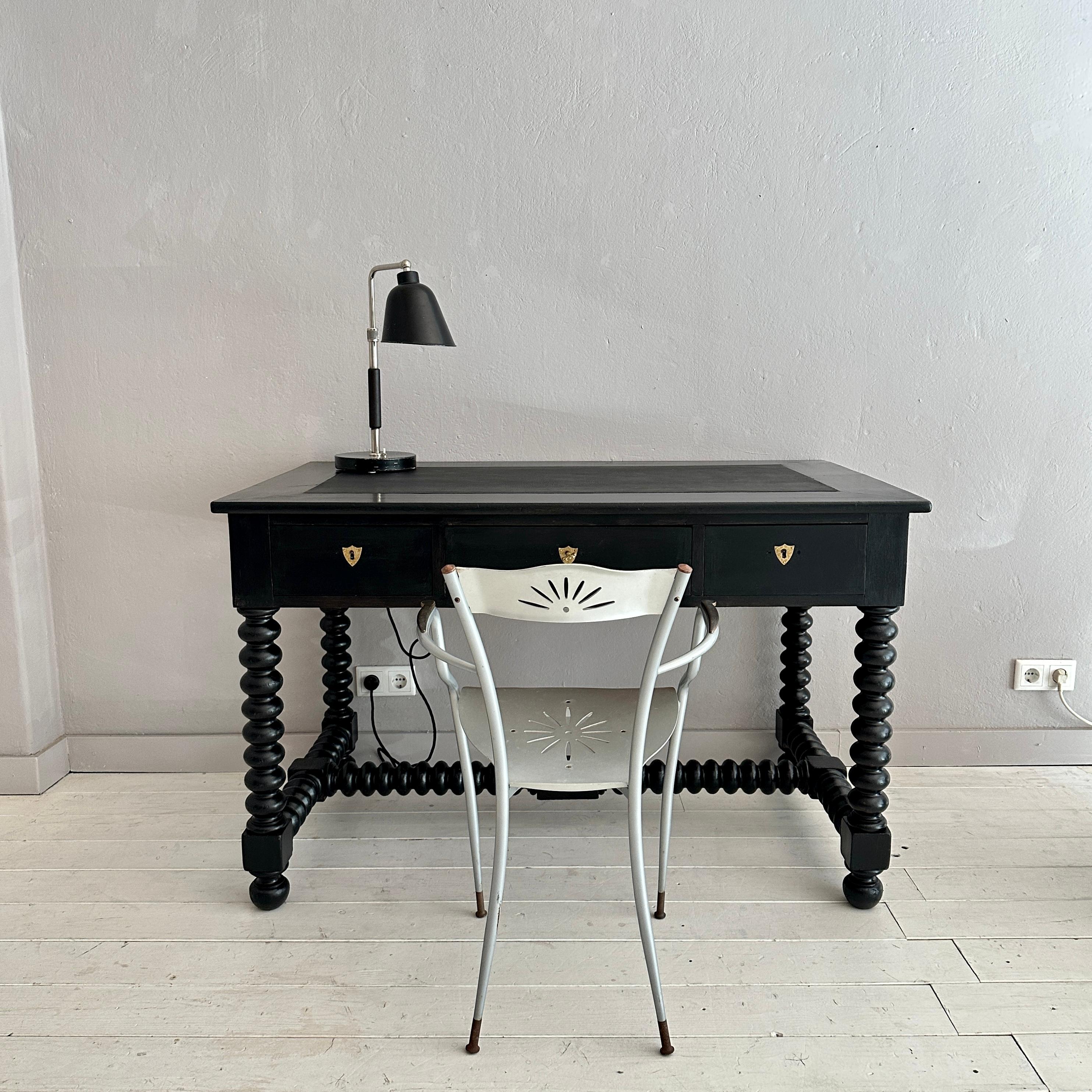 This beautiful Antique Brutalist was made around 1880s in the United Kingdom. The black lacquered desk has got a black leather Top and turned Bobbin Feet.
The piece is in great vintage condition. The leather top gor recently replaced.
A unique piece