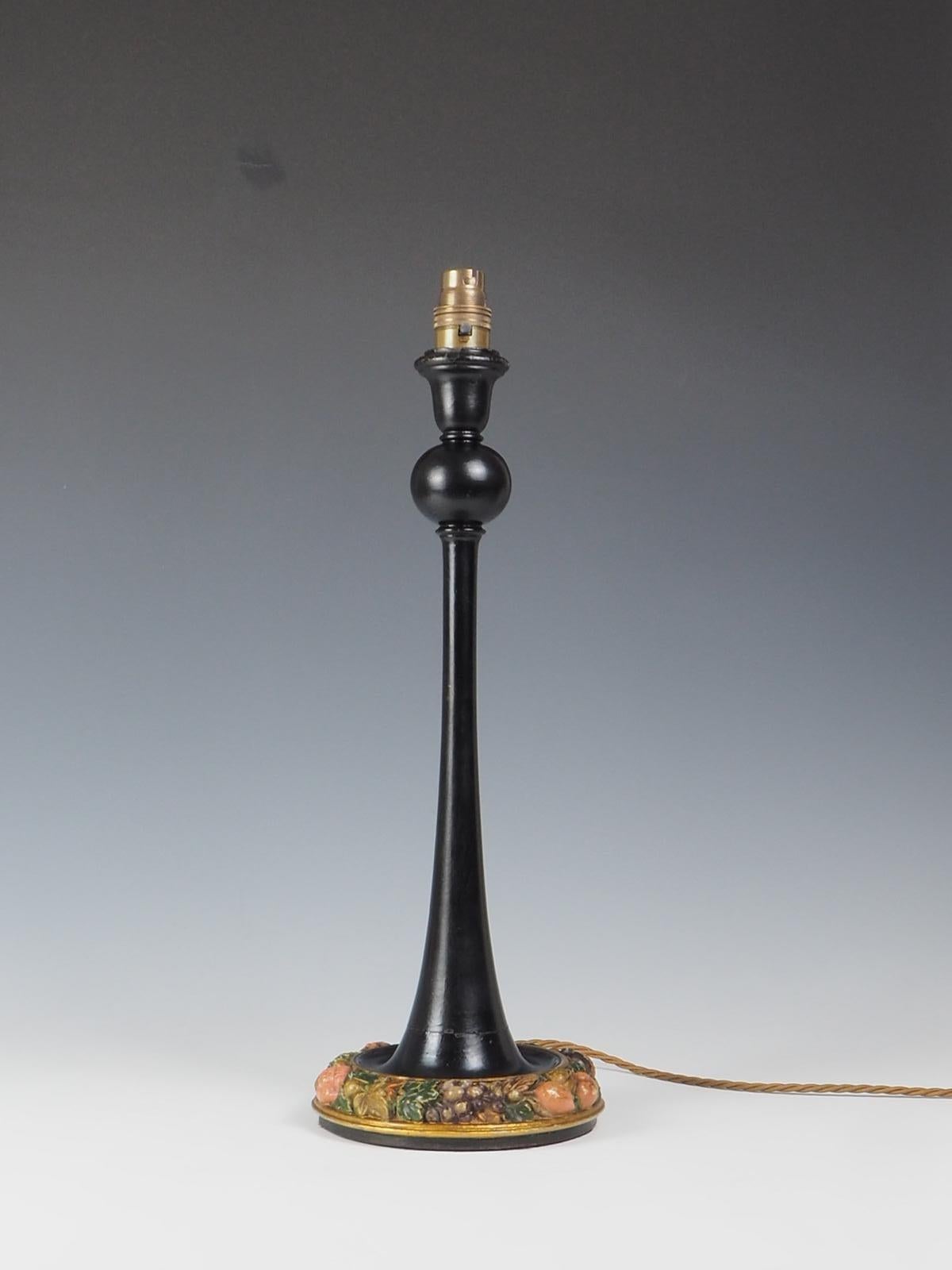 La lampe de table antique en bois sculpté et peint aux fruits est un ajout étonnant à toute maison.

Cette lampe de table élancée, peinte en noir, présente de magnifiques sculptures complexes de fruits colorés autour de sa base. Le design antique