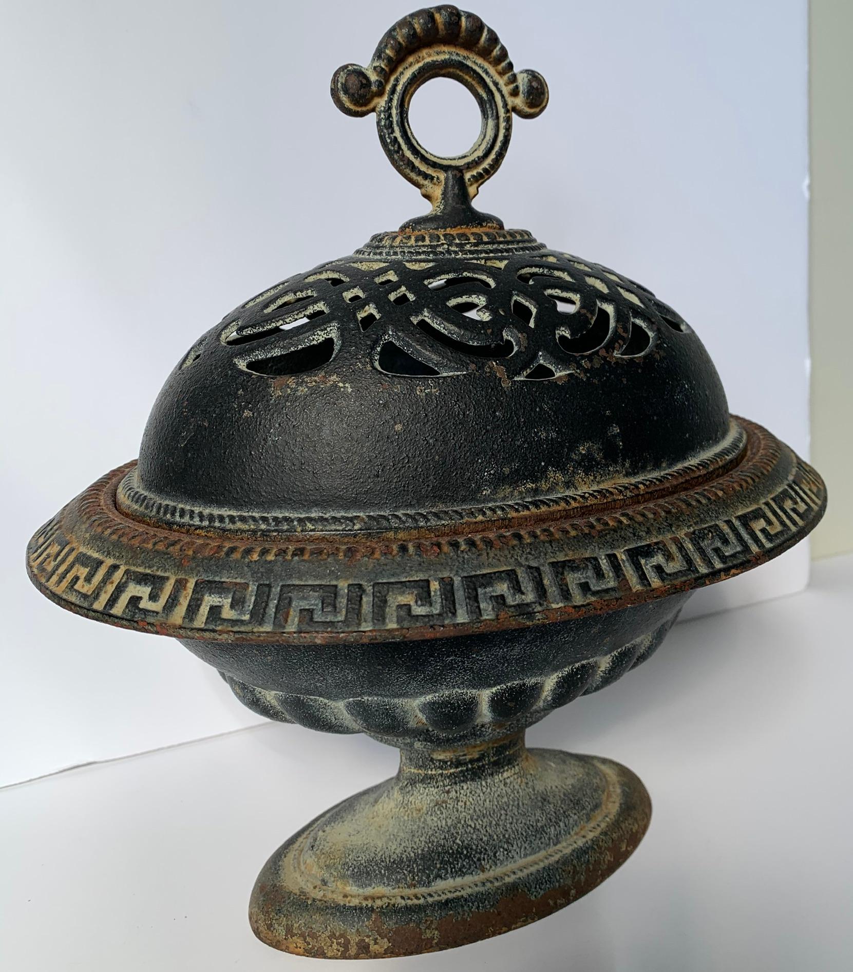 Antique black cast iron urn or cache pot. Greek key detailing and pierced openwork top. Would work well for porporri or flowers. No makers mark. Suitable for indoor or outdoor use.