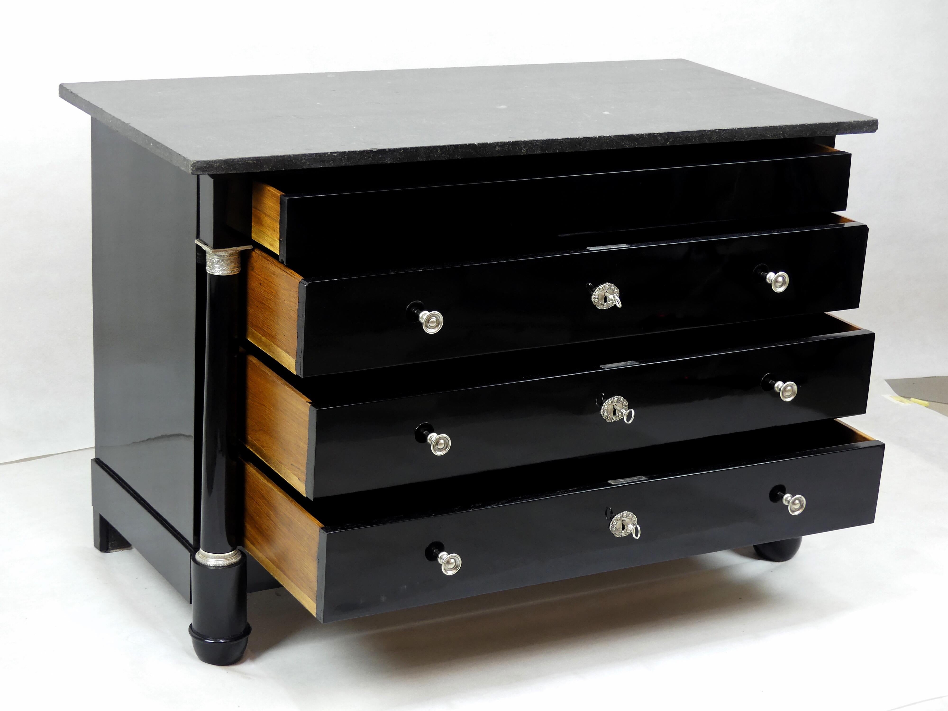 An original antique Empire chest of drawers from the early 19th century from France.
The corpus of the commode is made from oak and is ebonized as well as polished.

The commode has four drawers and an original marble top. On both sides, it is