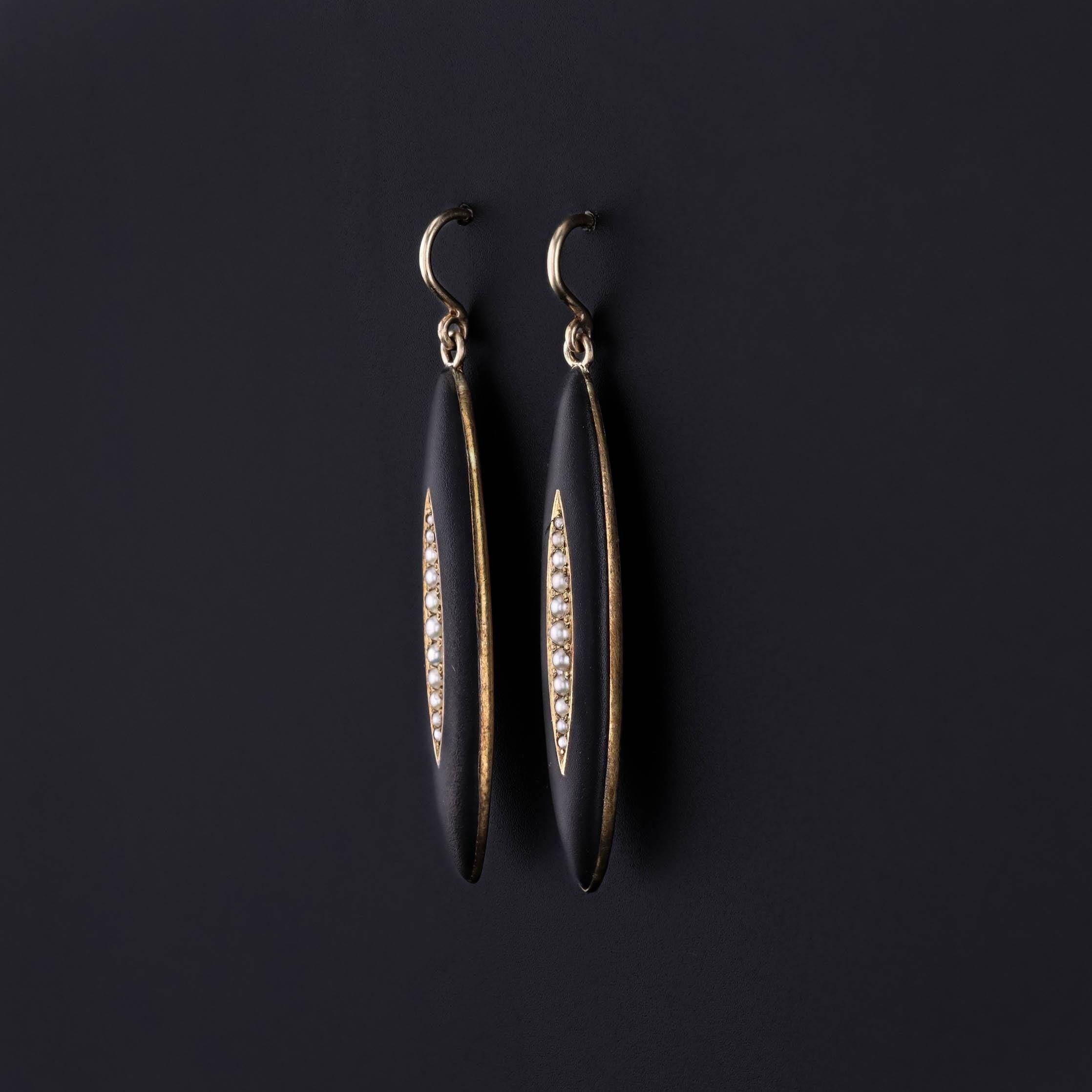 Antique Black Enamel Earrings: These earrings feature navettes of pearls and black enamel, set in 14k gold. They were created from antique bar pins (circa 1900) by removing the pin findings and adding 14k gold ear wires.

Each earring measures 1.5