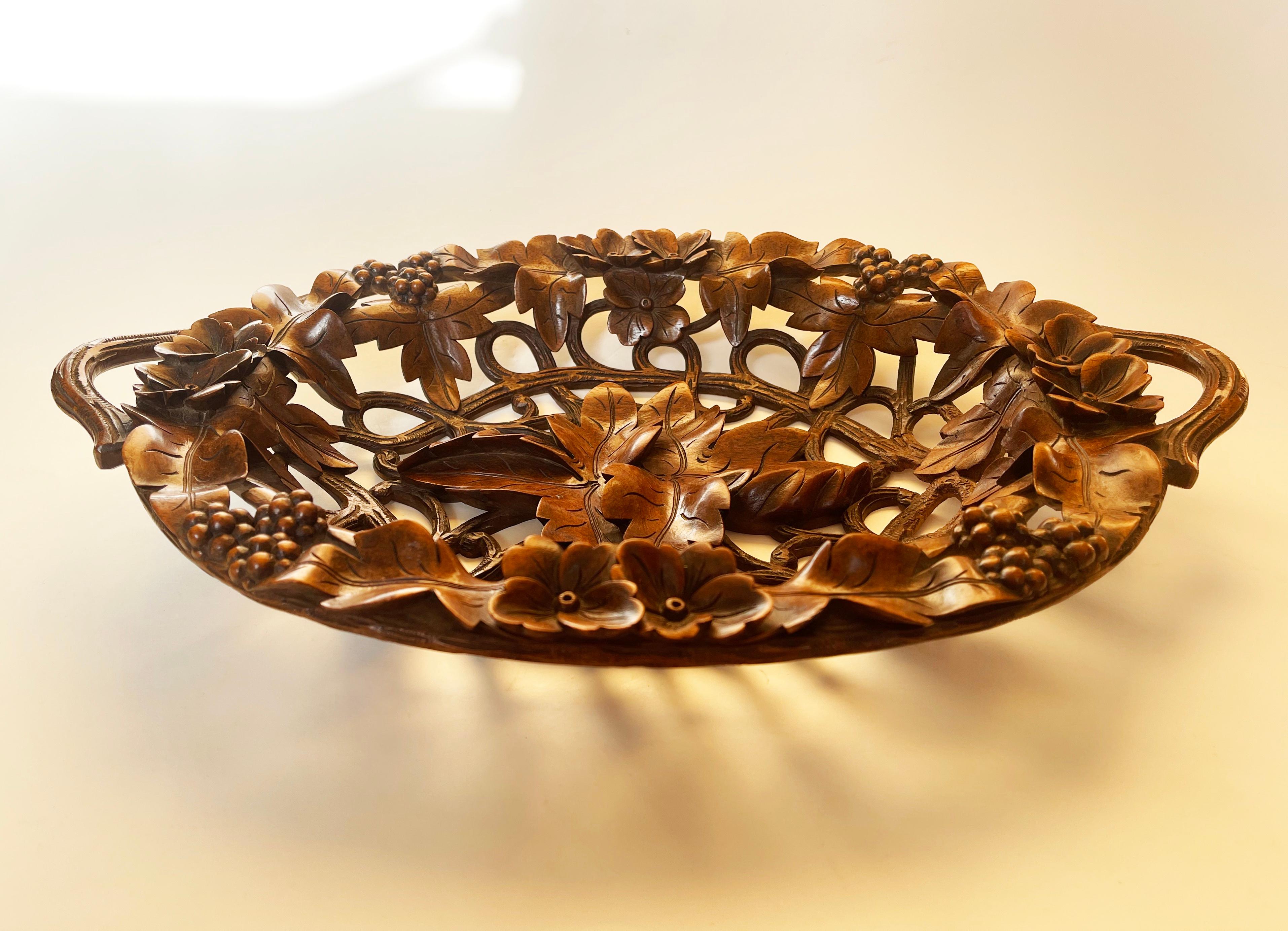Large and expressive – in fact absolutely unique hand carved bread basket or bowl from the Black Forest, Germany.
Made from intricately shaped & polished dark walnut wood.
Made from walnut, it features forest berries, overlapping leaves and flowers