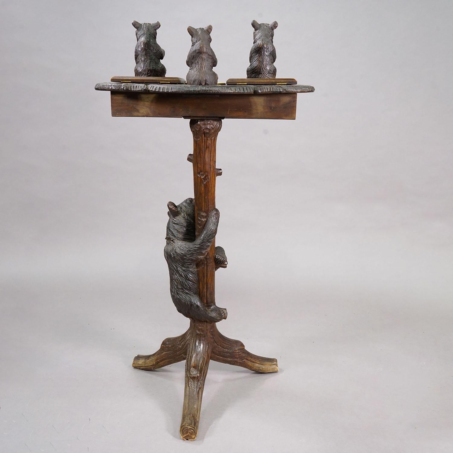 Antigua mesa auxiliar / de fumar con oso tallado Black Forest, ca. 1900

Mesa de la Selva Negra finamente tallada con un soporte central en forma de oso trepador sobre una base trípode con patas en forma de ramas. El tablero oval está ricamente