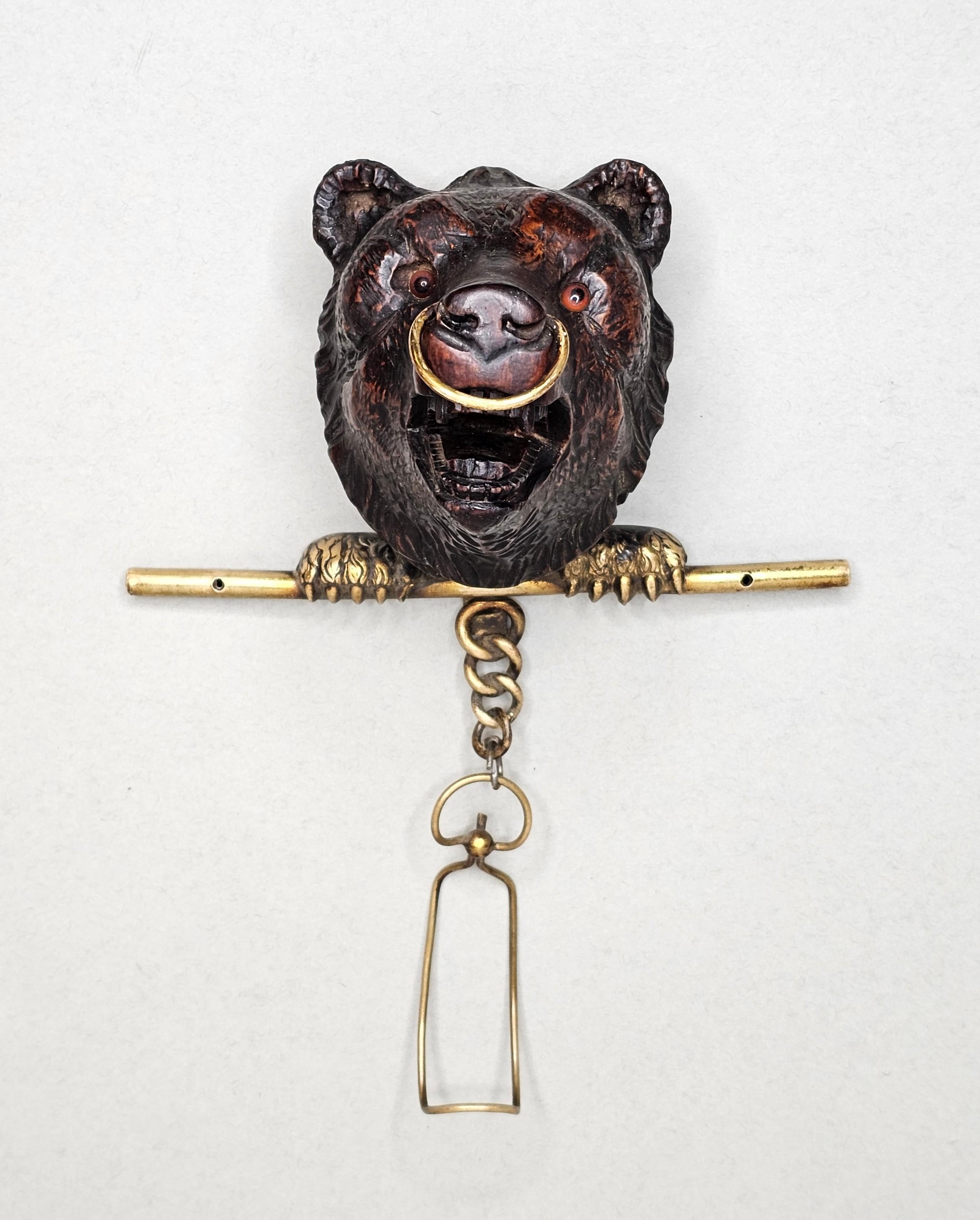 A rare and exceptional hand carved German Black Forest wall-mounted hanger. circa 1890

Born in the late 19th / early 20th century, featuring an intricately carved walnut figural bear's head with inset glass eyes, finely detailed gilt brass paws