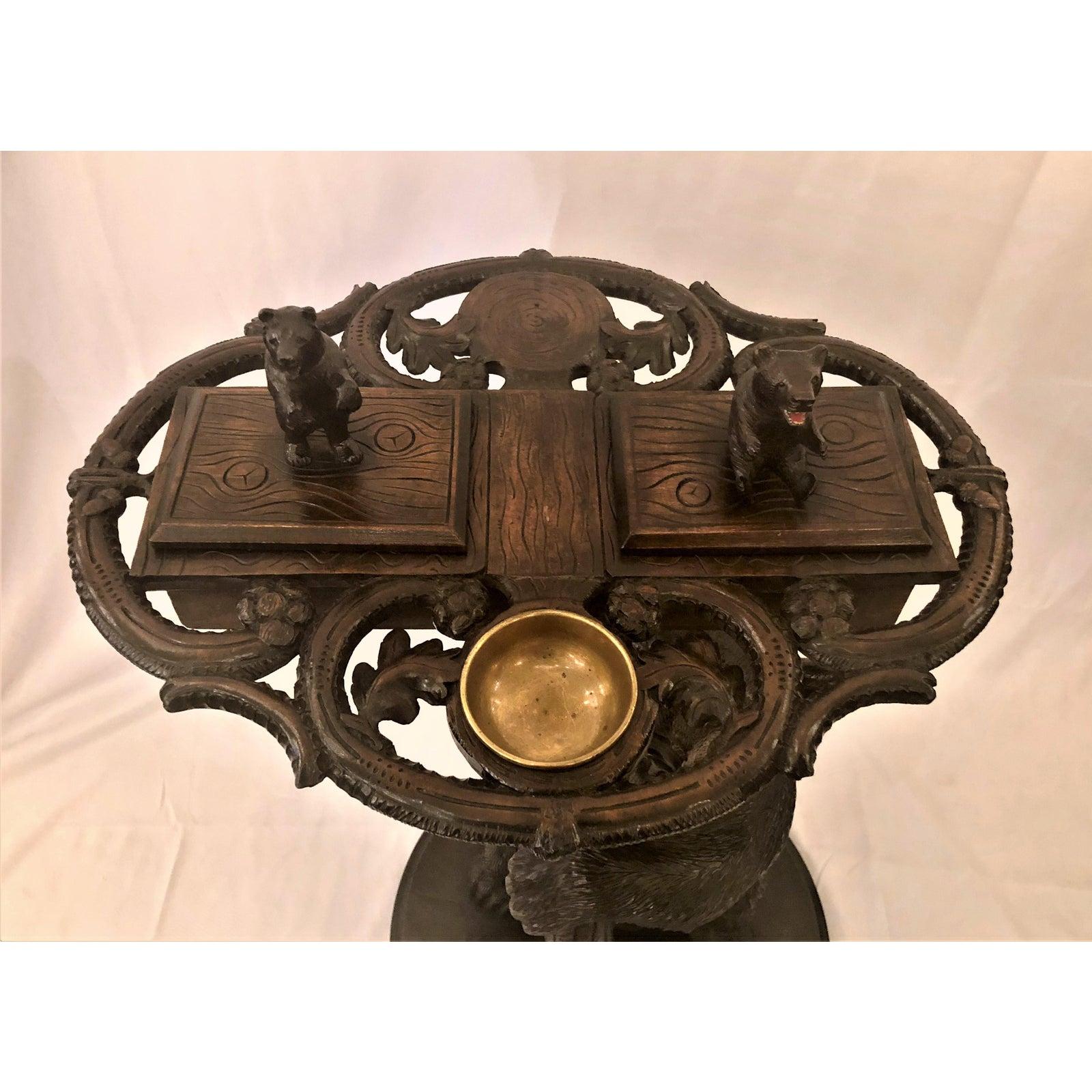 Antique black forest carved oak bear smoker's stand, circa 1880. This is an amazing stand and with the additional fanciful element of a music box, somewhat over the top. The bear's head rolls back for storage. This would be a conversation and a fun