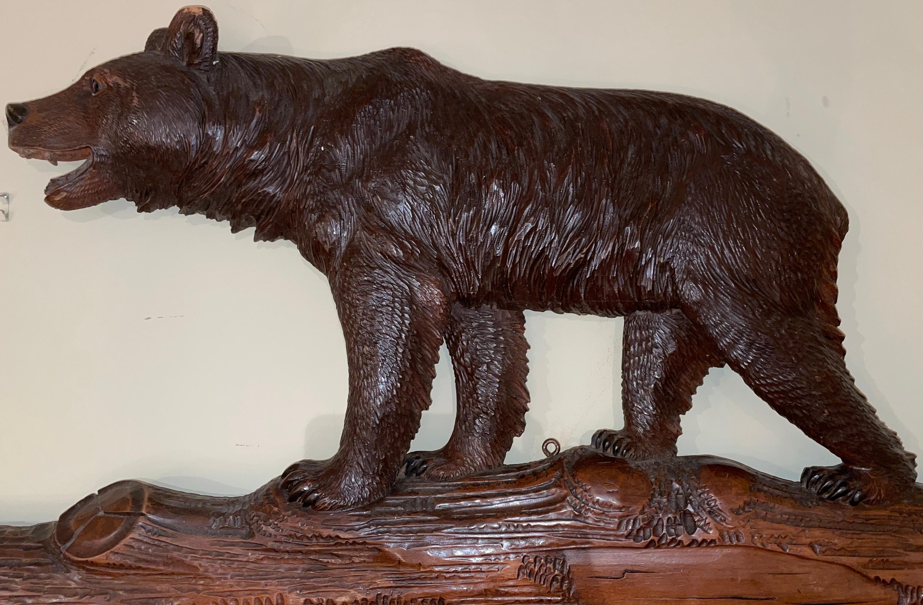 Grand Scale Antique German black forest carved walnut beveled mirror with figural bear at top, circa 1890.