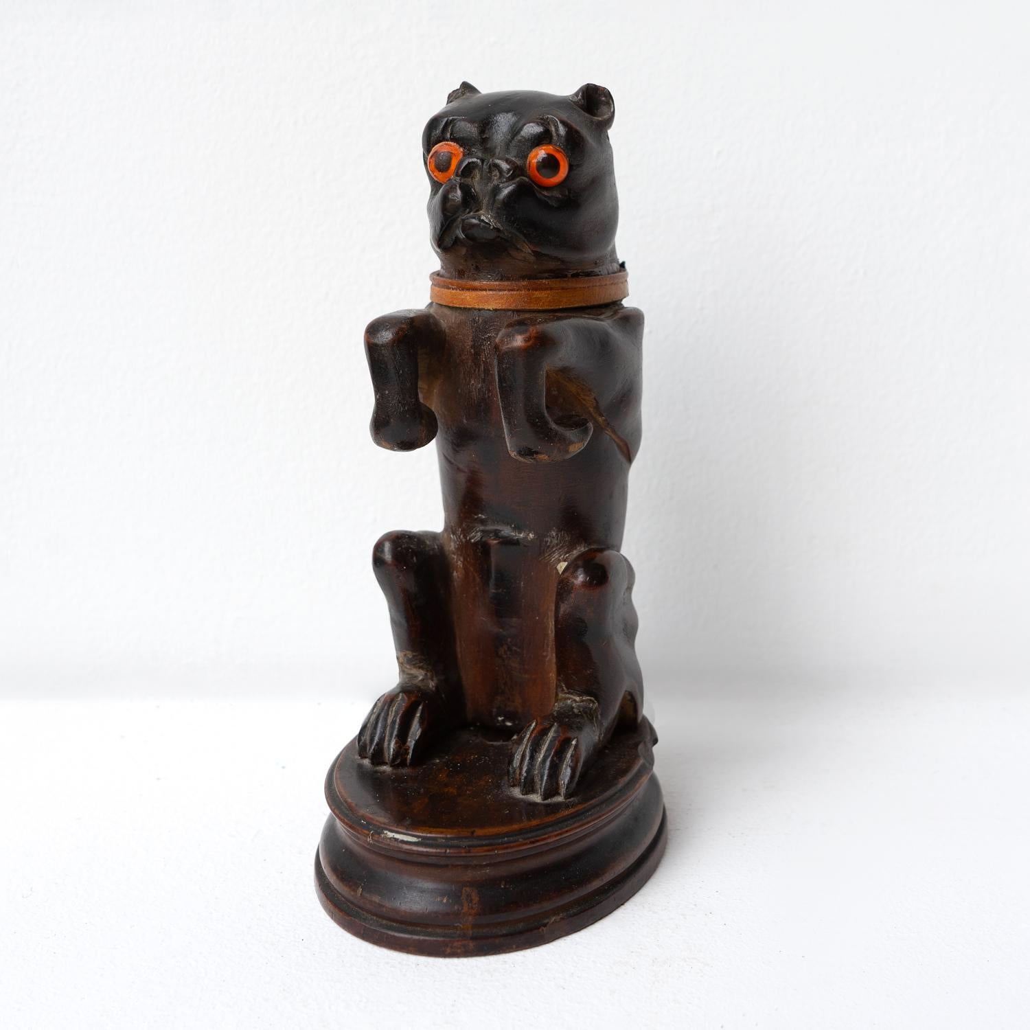 Antique Carving in the Form of a Dog

Raised up on his hind legs, the head with original glass eyes tilts back to reveal the original glass inkwell inside. The arms are curved round so he can hold a pen.

Probably carved from linden wood.

It is in
