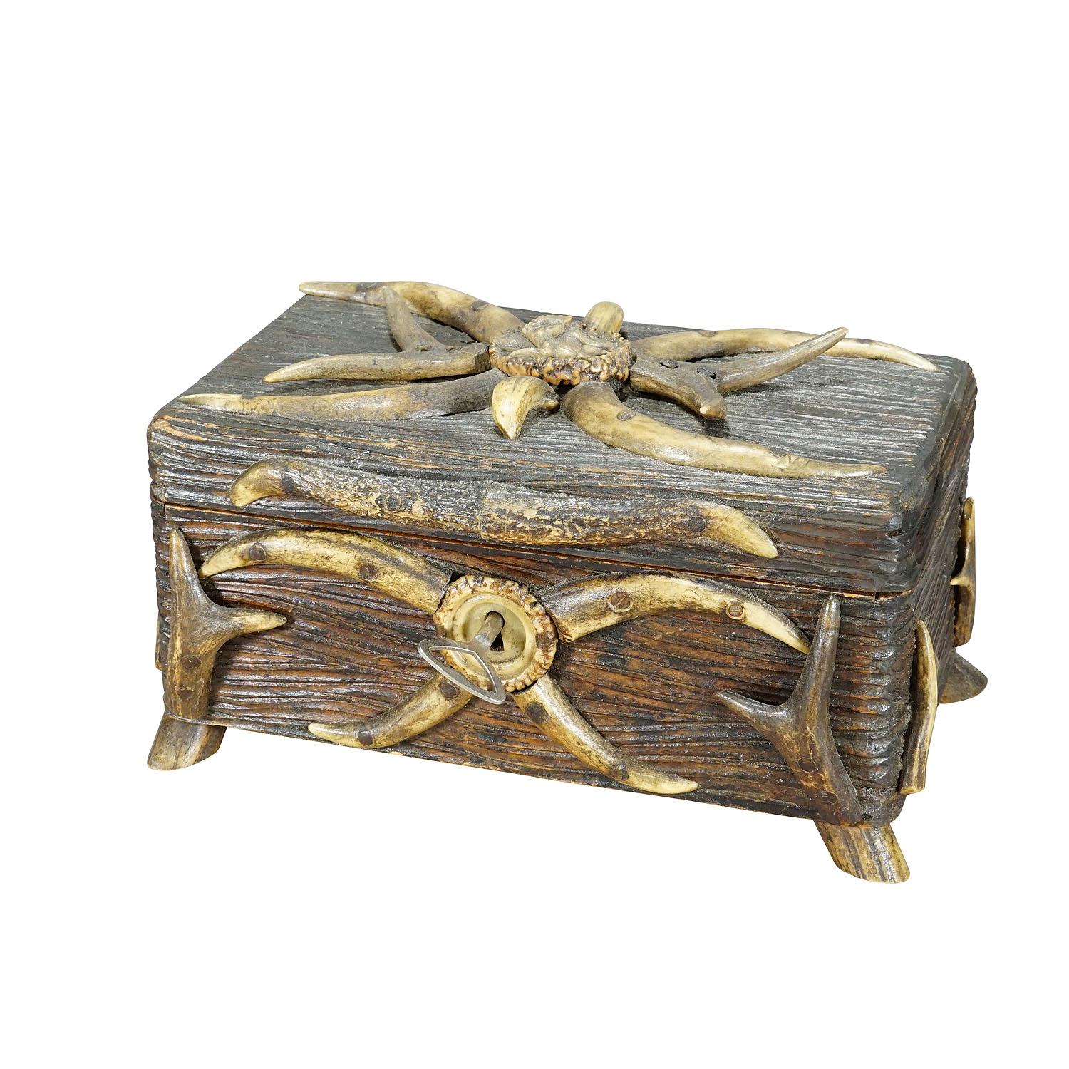 Antique Black Forest Casket with Antlers Decoration circa 1900s

A marvelous rustic wooden casket or cigar box. It is made of handcarved pine wood panels, decorated with several deer antler pieces and wild boar tusks, on the lid with fine carved