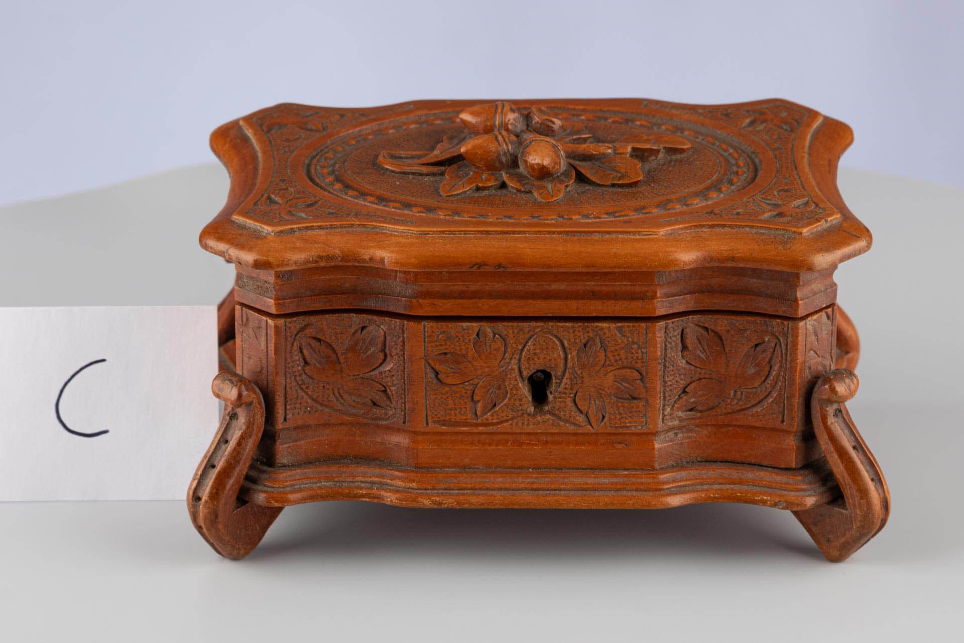 Antique Black Forest Hand-Carved Brown Wooden Trinket Jewellery Box 

Continental
Wood, Textile, Metal
c. 1900

Dimensions: H x W x D: 9cm x 15cm x 9.5cm

This hand-carved trinket box is crafted in the renowned Black Forest style. Emerging in the
