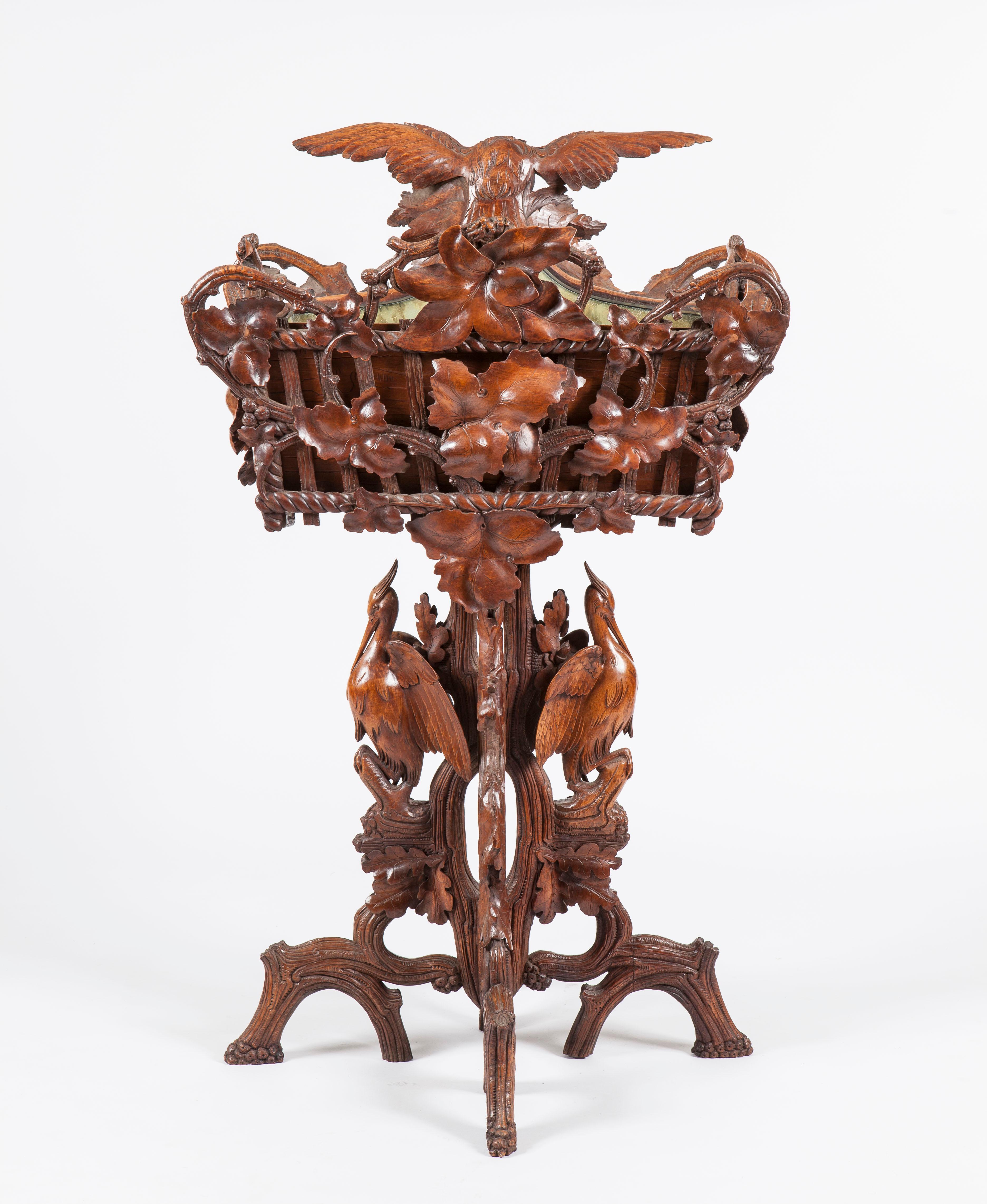 Constructed in a well carved lindenwood, rising from quadripartite feet, naturalistically, representing branches, supporting a tree form central column dressed with two storks and supporting a carved rope dressed rectangular plant trough, profusely