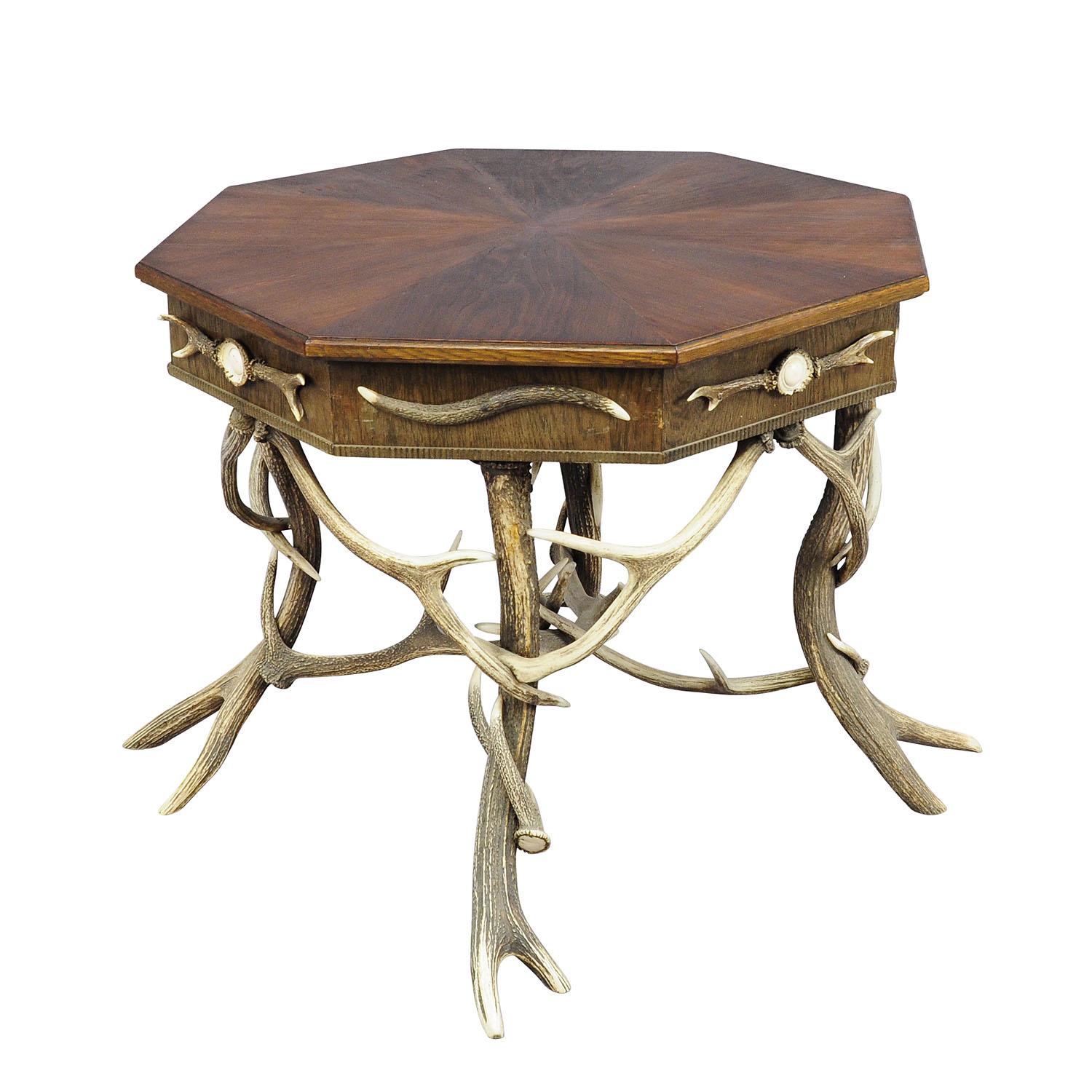 Antique Black Forest rustic antler table ca. 1900.

A large antique octagonal antler table. Decorated with several antlers from the deer and stag. Each corner with turned horn roses. Restored walnut top with carved border. executed n Germany around