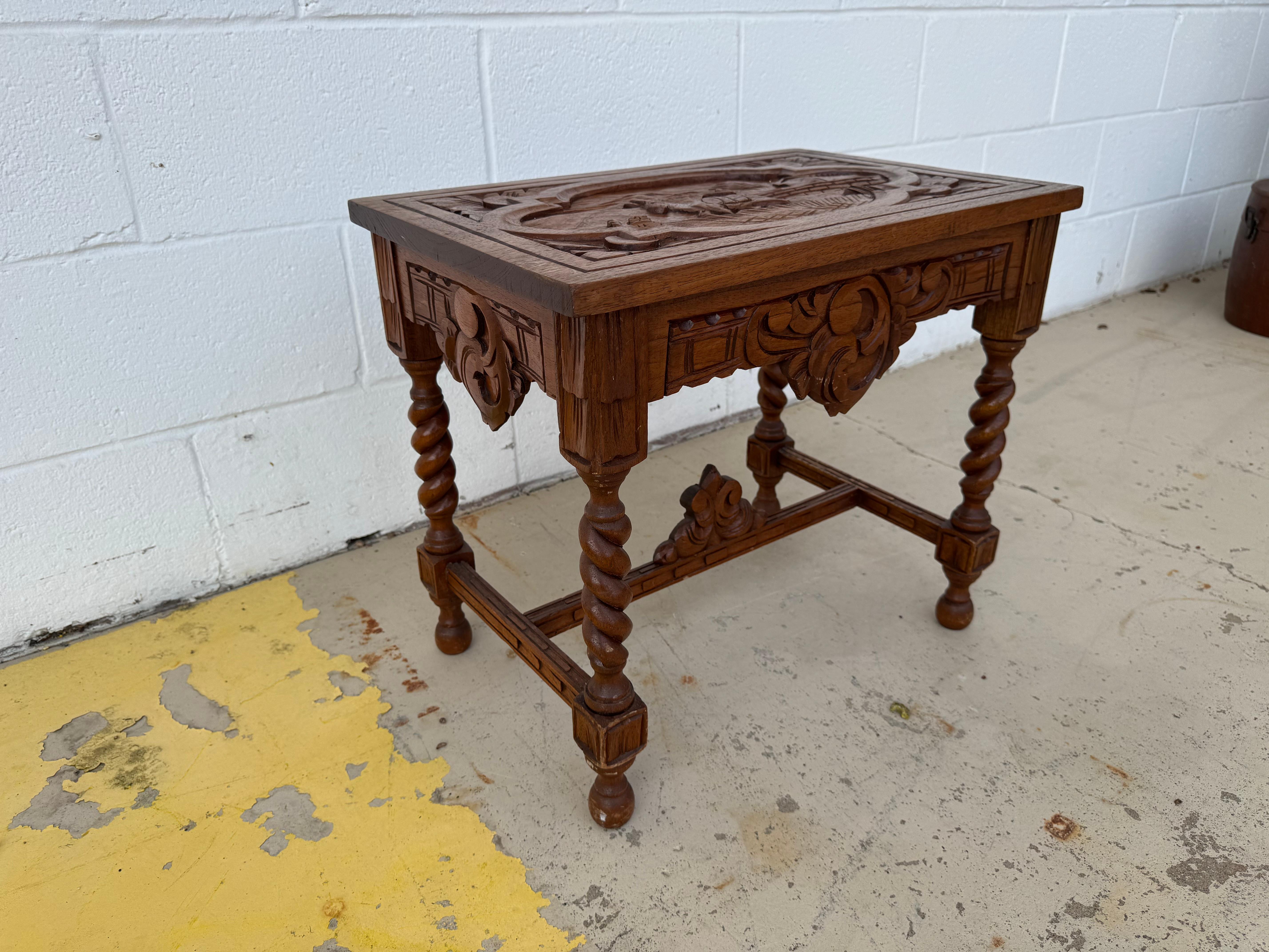 Carved from walnut, this table was possibly made in Germany.
It favors the work stemming from the Black Forest.
The legs are carved in the barley twist style.
The skirt is carved in a floral pattern.
The top has a cottage with a mule in the