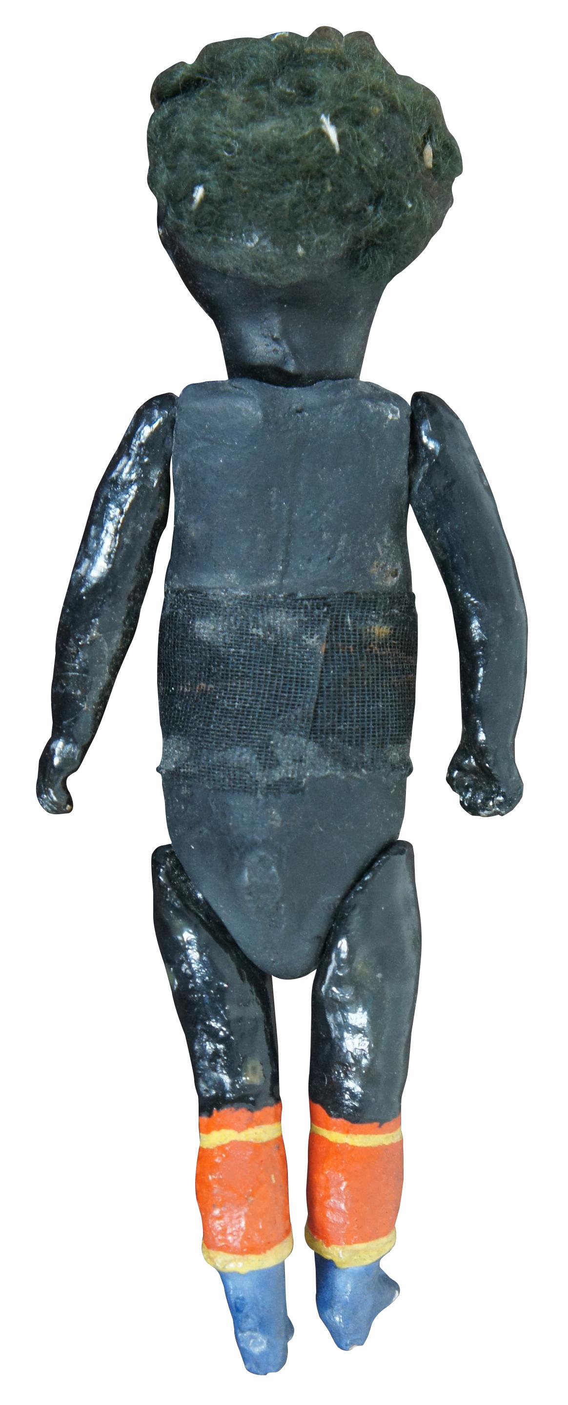 Antique 19th century black doll with full bisque body, jointed limbs and blue and red painted boots. Measures: 8.5”.
   