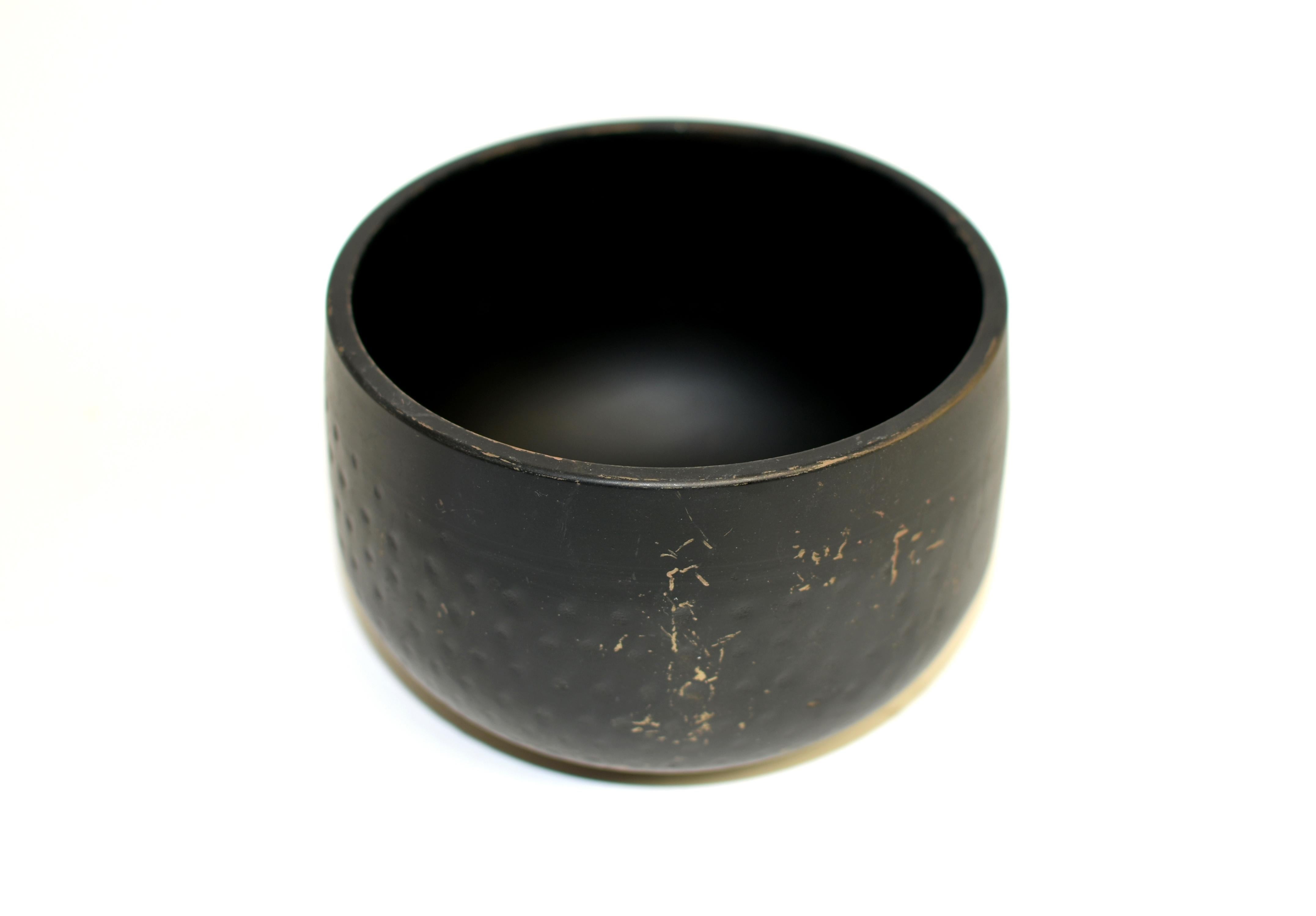 A beautiful solid black antique Japanese singing bowl in excellent condition.  Crafted in solid bronze with hand hammered divots, the bowl embodies the classic Japanese aesthetics where beauty is found in nature, order and simplicity. Black