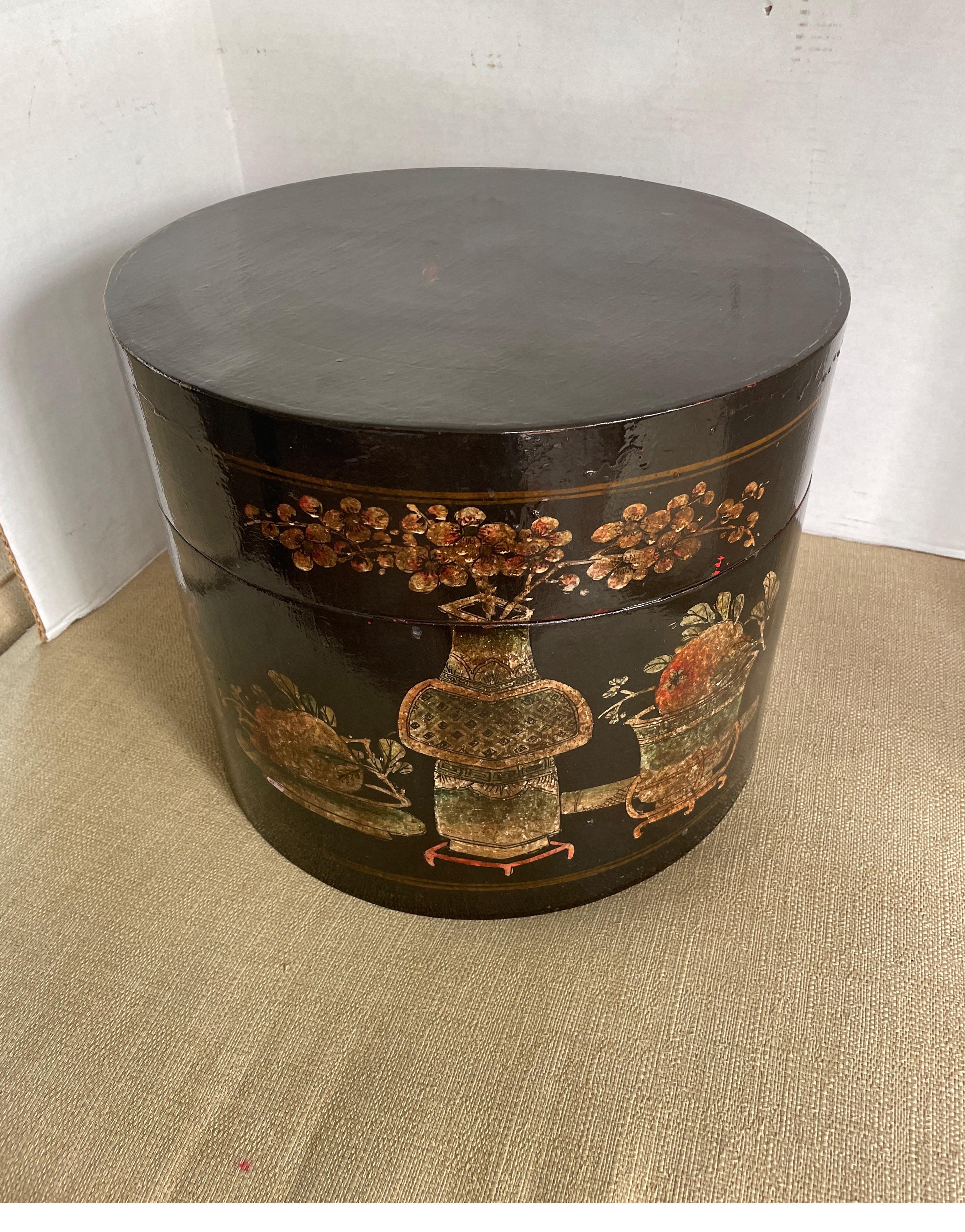 Antique black lacquer container with painted floral motifs used to store hats and personal belongings.