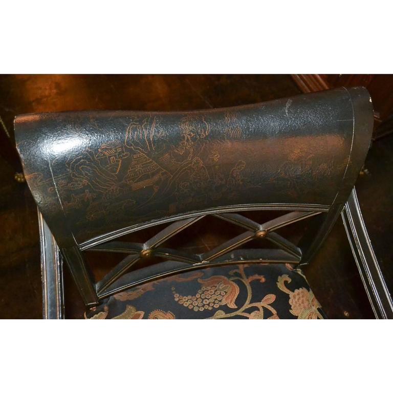 Nice quality early 20th century English Regency black lacquered armchair with upholstered seat and having a contoured back with a faintly painted Oriental motif back.