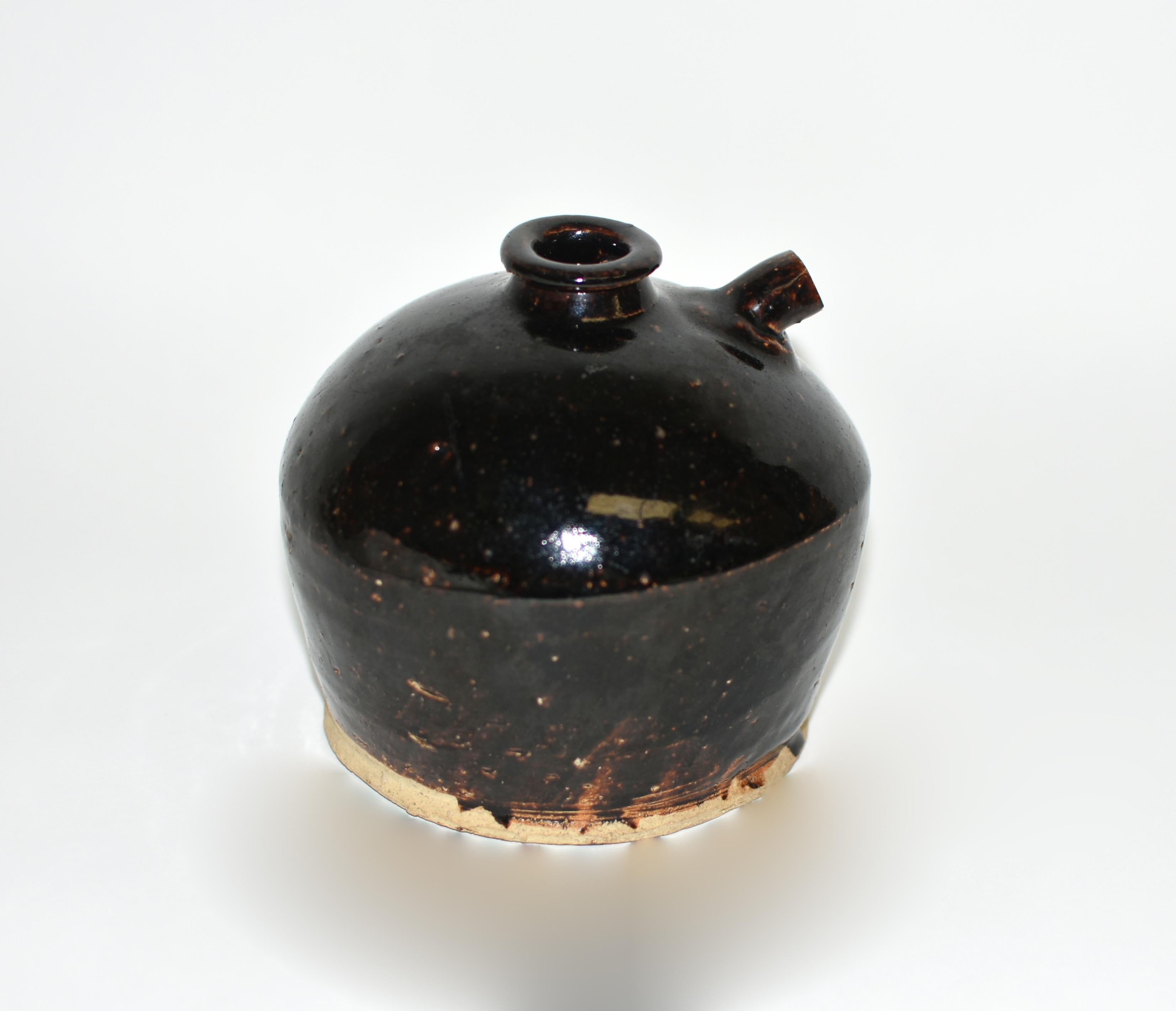 Questo caratteristico vaso di aceto proviene dalla provincia di Shan Xi, nel nord della Cina, rinomata per i suoi eccezionali aceti invecchiati. Presenta una forma unica con un unico piccolo germoglio. Il corpo arrotondato si innalza da un piede
