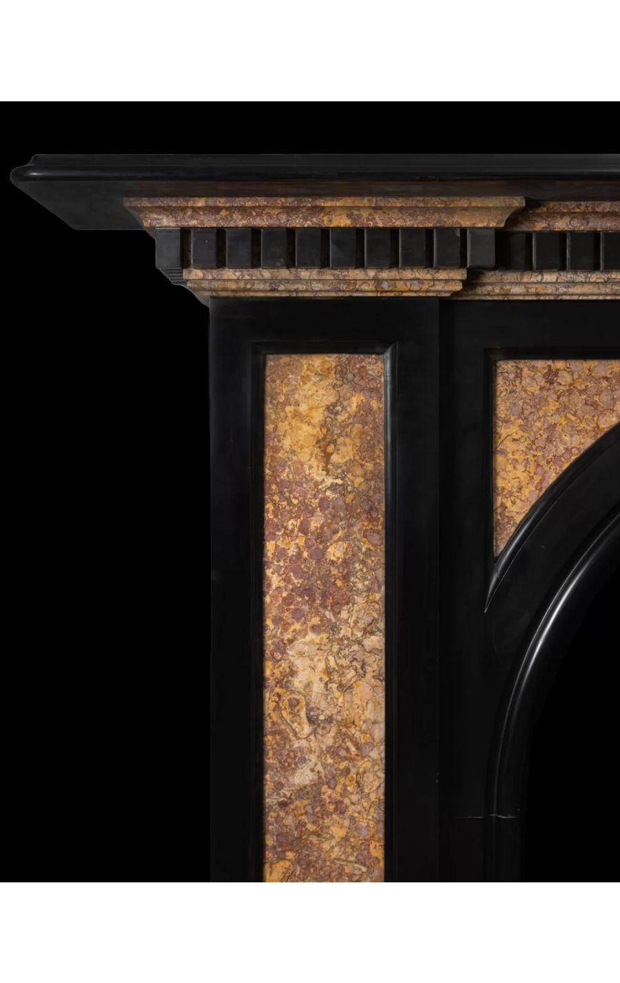 A large antique black marble fireplace with coloured Brocattele marble panels and mouldings.

The black marble pilasters and arch spandrels have recessed and inlaid panels of semi-precious Spanish Brocattella marble. The layered Brocattella