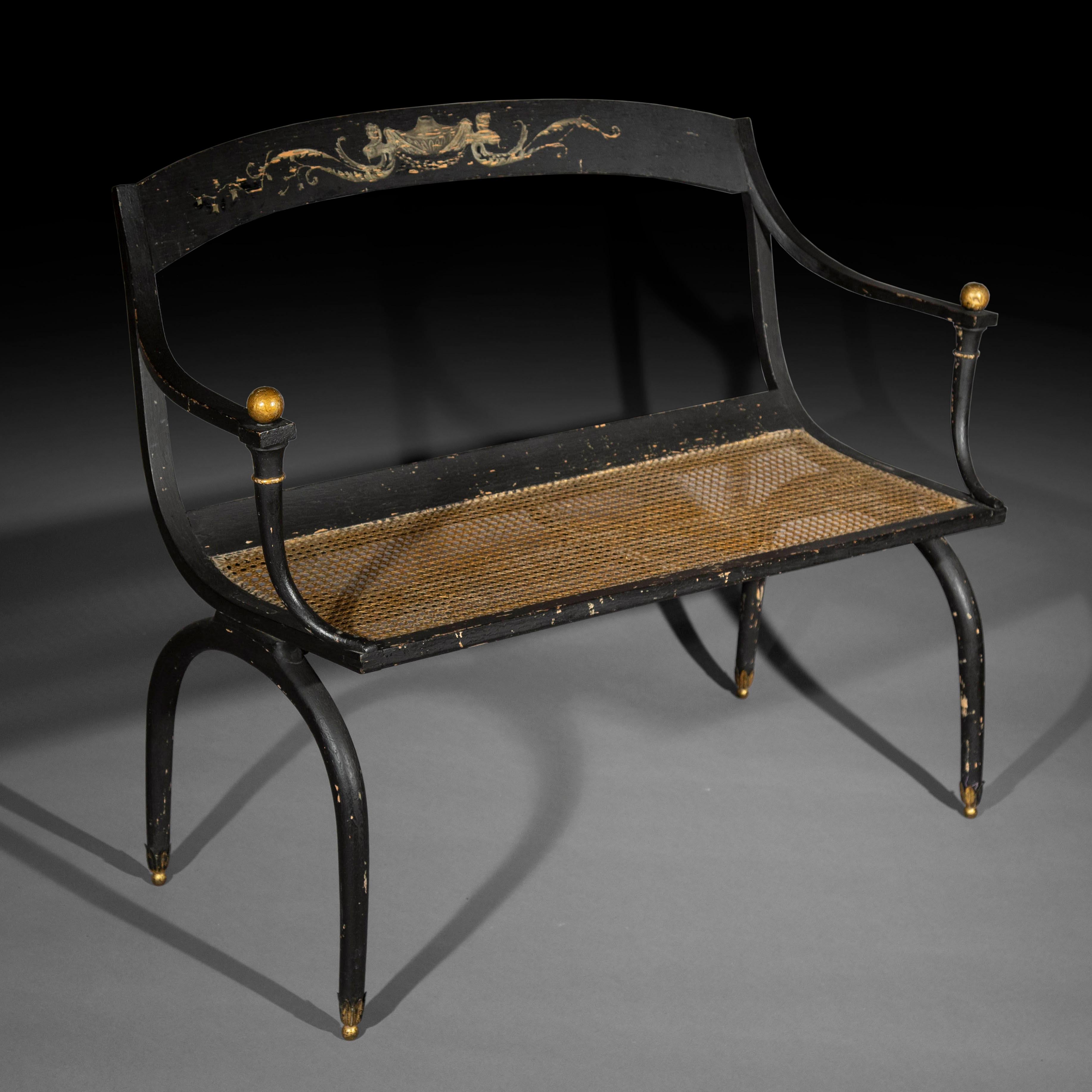 A very decorative Empire style settee of Curule form, parcel-gilt and black painted to simulate patinated dark patinated bronze. In the style of Jean-Joseph Chapuis, (1765-1864). A squab cushion covered in a fabric complimenting other textiles in