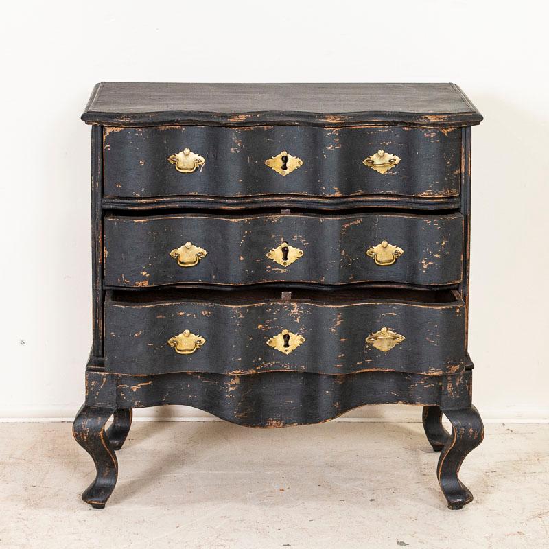 This small chest of drawers is quite dramatic thanks to the (newer) black paint that is gently distressed, accenting the Rococo curves and cabriole feet. The size makes it adaptable to use as a nightstand, side table or simply small chest of