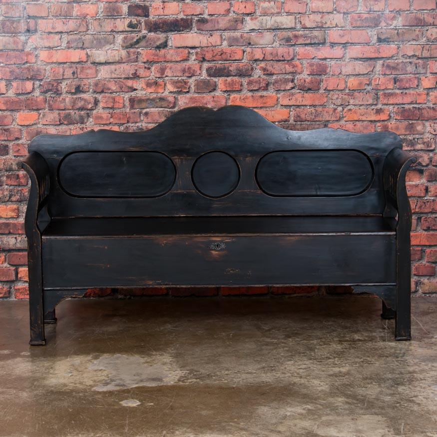 This lovely pine bench is a wonderful example of Swedish country craftsmanship. The gentle curve of the arms and recessed panels add to its allure. The hinged seat opens to reveal storage space below with two compartments. The bench has recently