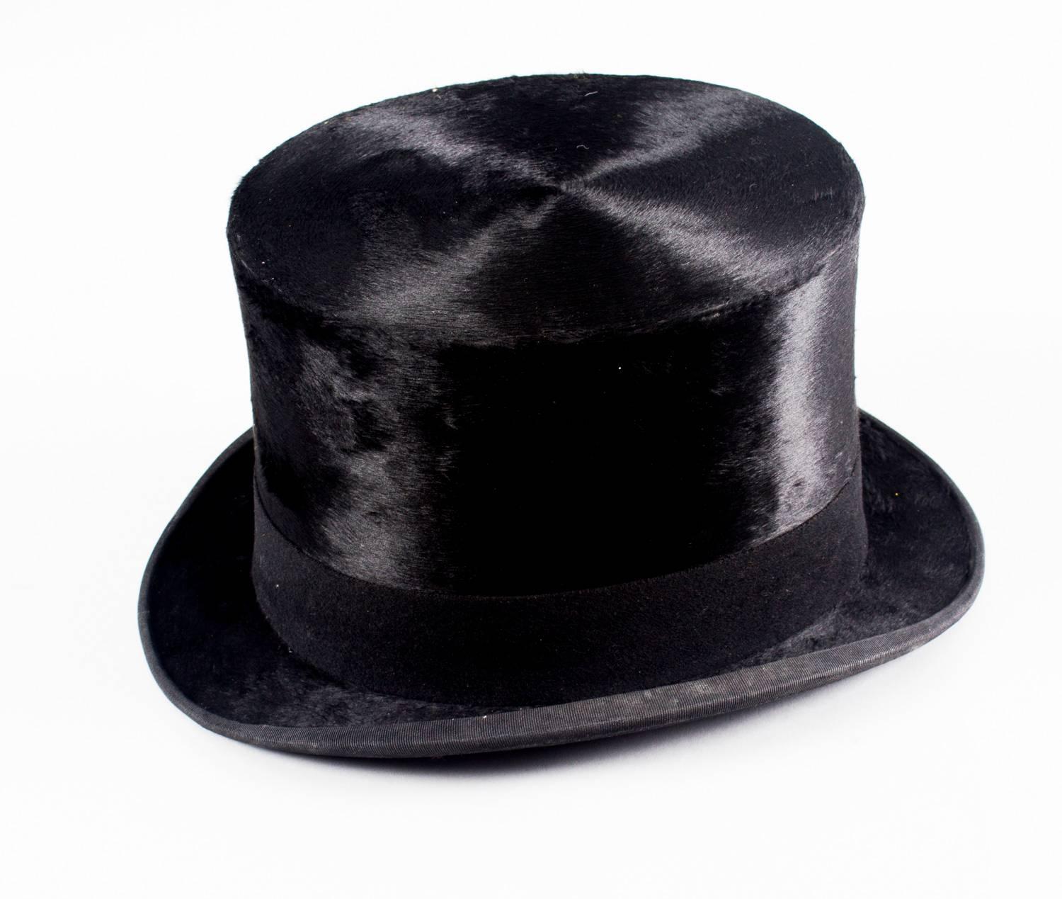 A fabulous Rowe of Bond street, London, black silk top hat, by appointment to Her Majesty Queen Mary, also stamped Christys' London, in a moire silk lined brown leather fitted travelling case, circa 1920 in date.

Christy & Co Ltd has been
