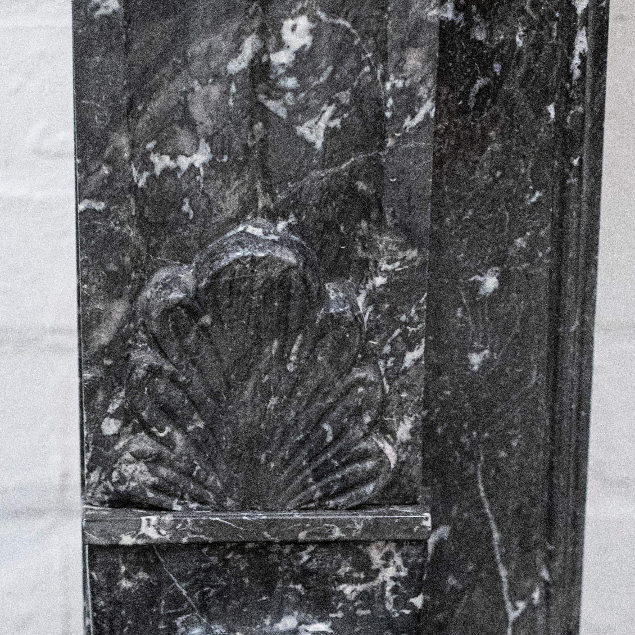 An imposing piece, this antique fire surround is in the style of Napoleon III, complete with Lion's Paw Feet, finely carved ornaments and consoles on the legs. 

The black Saint Anne's marble has beautiful white veining and inclusions throughout.