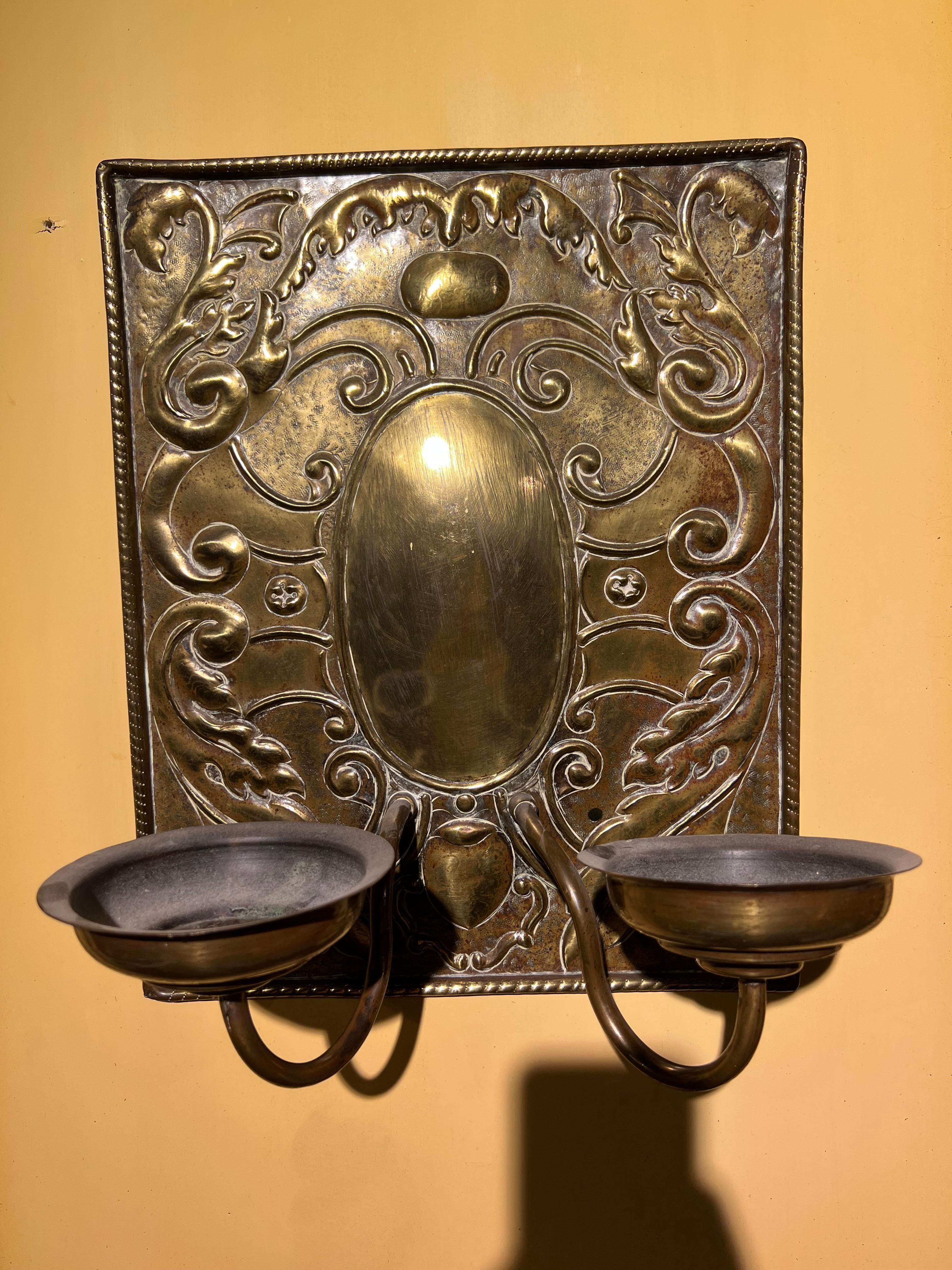 Antique blaker / sconce with a heavy wall plaque. The frame is made of brass. There are beautiful decorations on the wall sign.