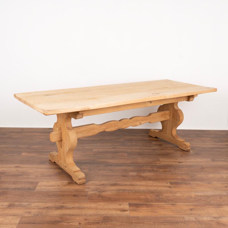 This impressive 7' French country farm table has been given new life with a bleached oak finish, adding a fresh look to this timeless classic. Note the thickness of the solid oak top and heavy trestle base. Unique to this table is the curves carved