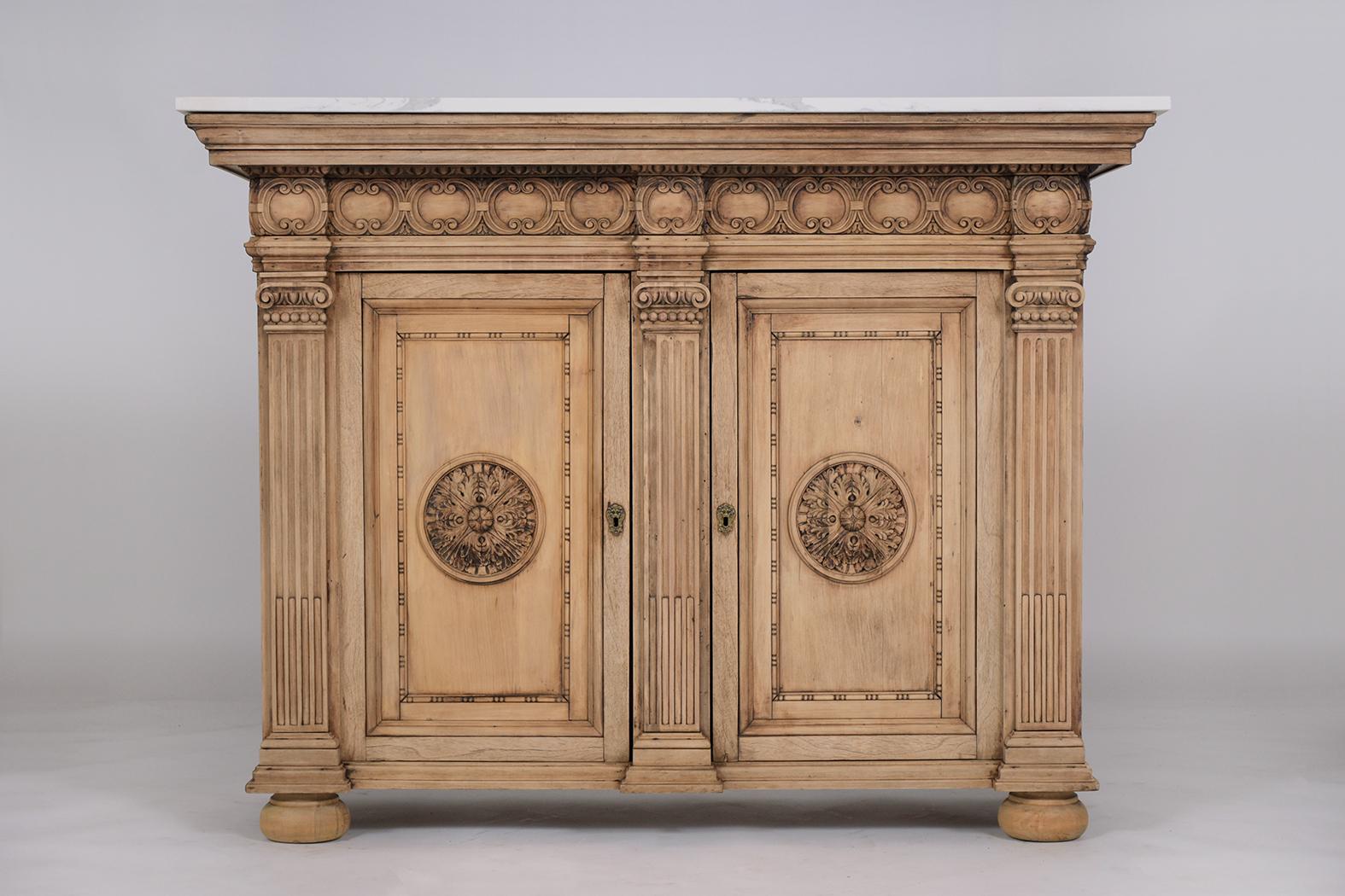 An extraordinary antique baroque cabinet beautifully crafted out of walnut wood in great condition completed restored by our craftsmen team. This server features a unique bleached wood finish, rectangular marble top, two framed panel doors with