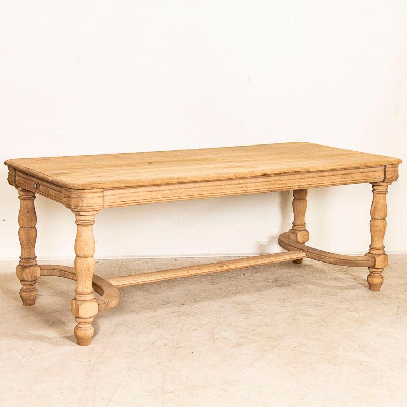 The heavy turned legs and curved stretchers along the bottom create drama in this refectory table. At 6.5' long, the bleached oak provide a fresh, contemporary feel to this impressive dining table with a drawer on each end. While it has not been