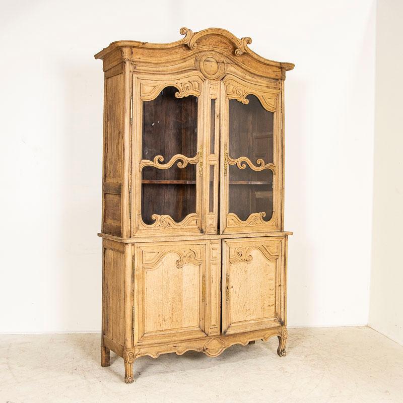 The traditional scrolled and arched crown is captivating in this French bookcase. The oak has been bleached, giving it a fresh look for today's modern home while bringing in the charm of French country craftsmanship. Carved, scrolled accents bring