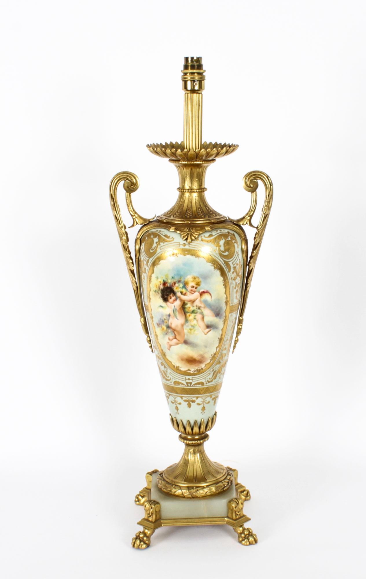 This is a stunning large antique French Sevres hand-painted porcelain and ormolu mounted vase circa 1870 in date, later converted into a lamp.
 
The ovoid porcelain body is painted with gilt-framed panels depicting finely painted cherubs at play
