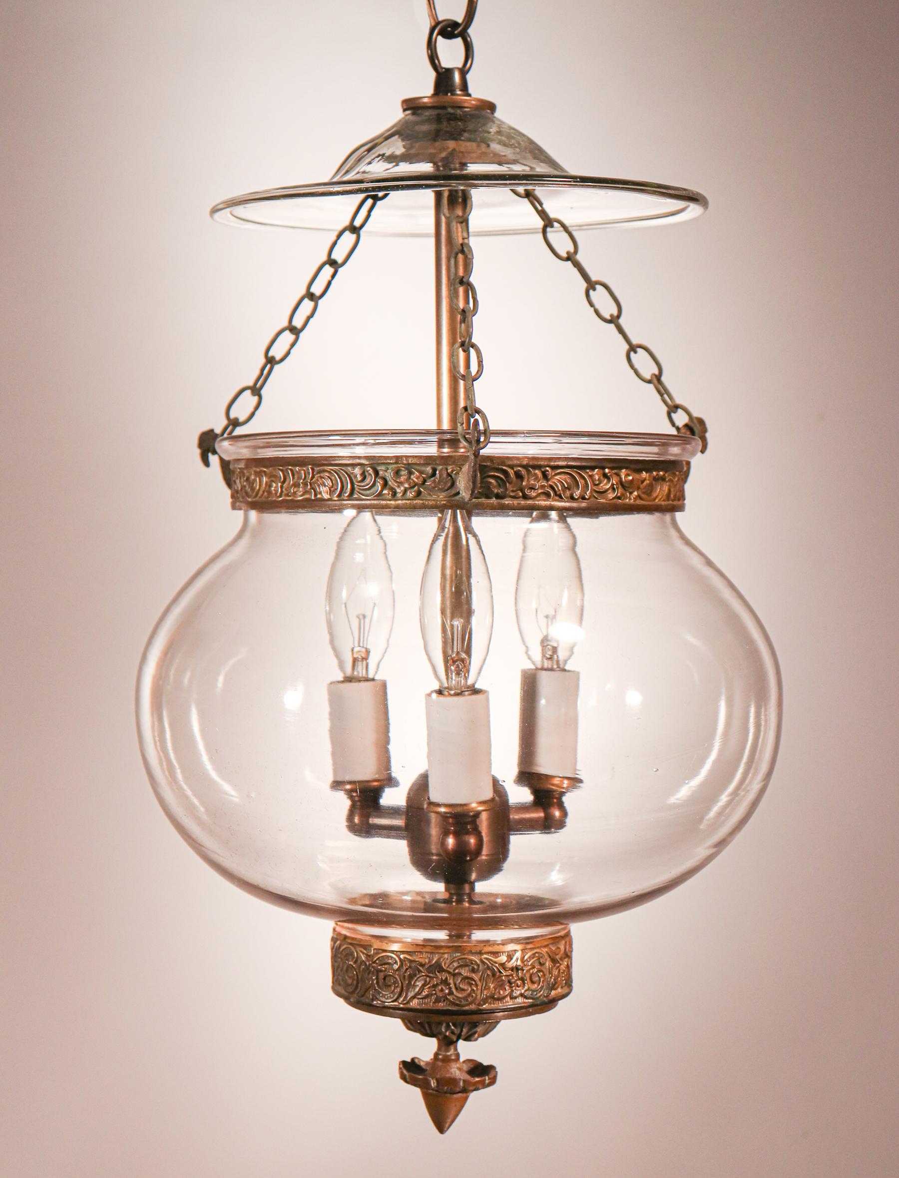 A truly beautiful antique globe bell jar lantern, this circa 1870 pendant features excellent quality hand blown glass (replete with desirable swirls and air bubbles) and all-original brass fittings—including its embossed band and finial/candle