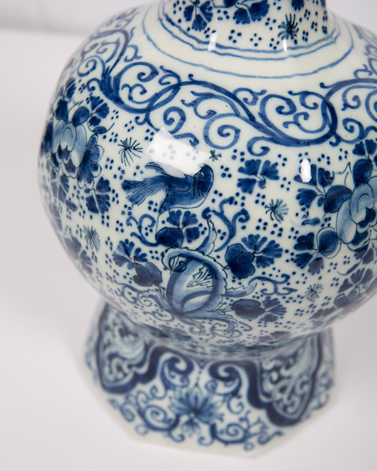 Antique Blue and White Delft vase hand-painted with a lovely all around pattern of songbirds among large flowers and scrolling vines. Made circa 1700-1705, the vase is decorated in deep cobalt blue. The octagonal design was popular in the time and