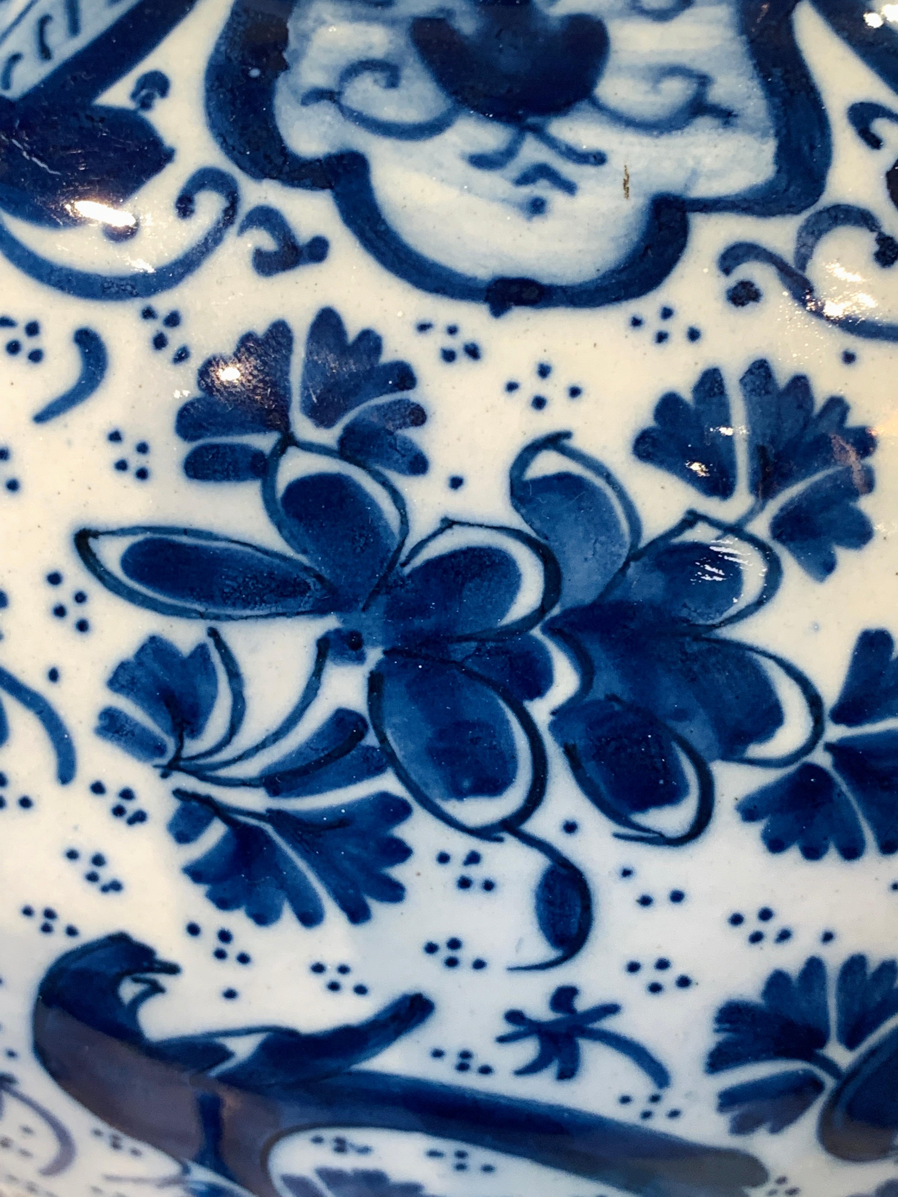 This beautiful Dutch Delft covered jar is hand-painted in cobalt blue with an exquisite overall pattern showing a songbird among flowers. The vase was made early in the 18th century, circa 1700-1716, in the De Drie Astonne factory owned and run by