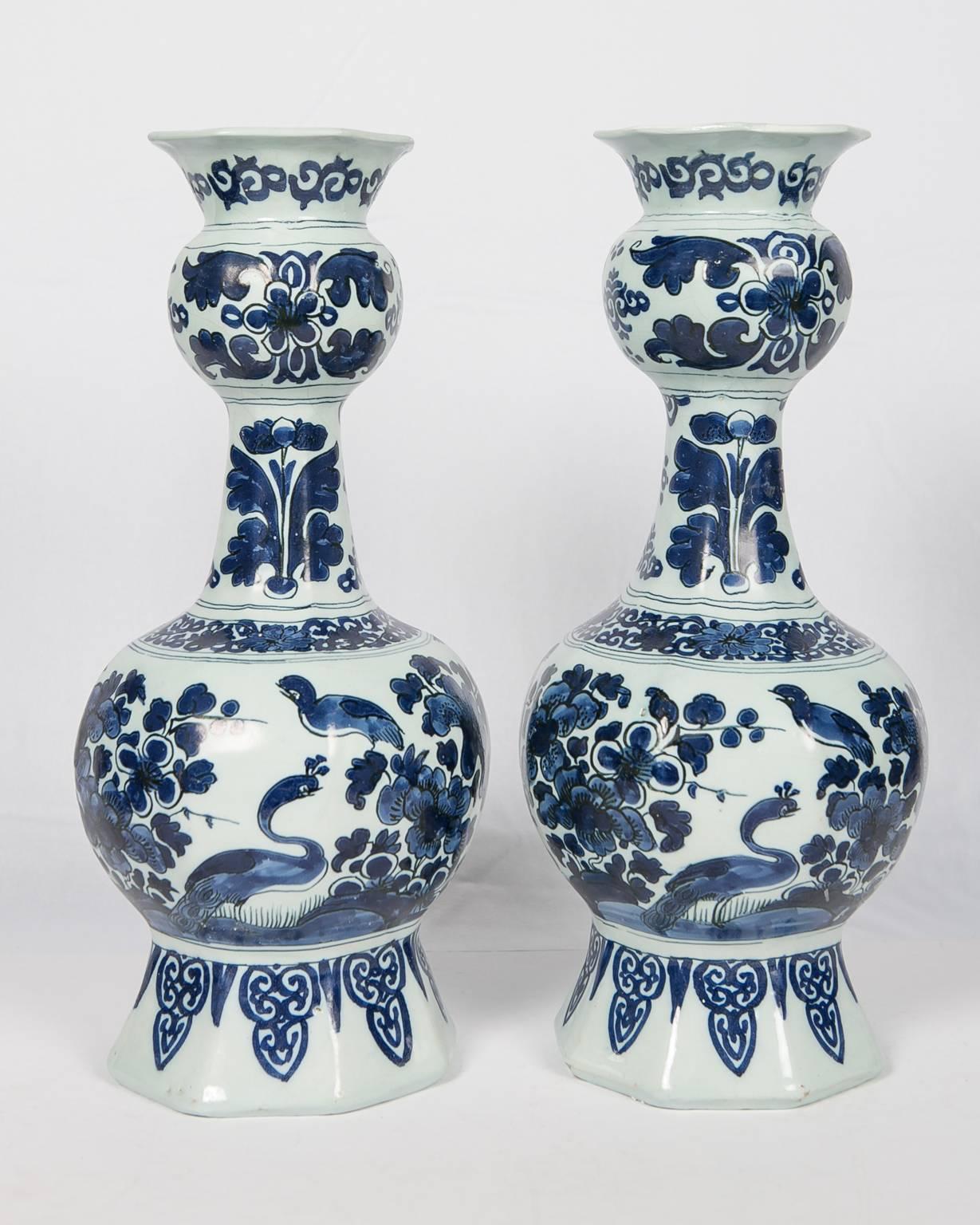 We are pleased to offer this pair of blue and white delft vases painted in dark cobalt blue with an all-around design
of peacocks, songbirds singing to the peacocks, and a large peony in a flower-filled garden.
The shoulder and top of each vase is