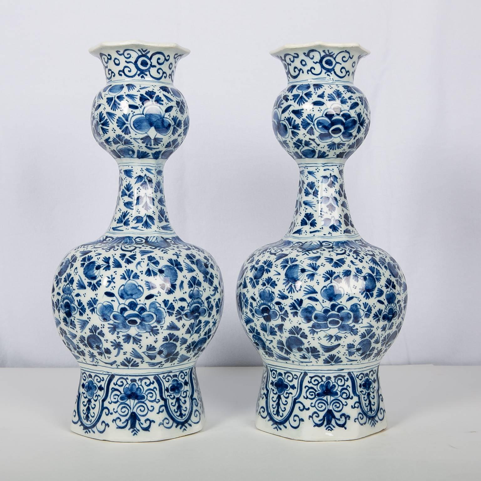 An exqusite pair of Blue and White Dutch Delft vases hand-painted in a medium cobalt blue with an all around scene in the 