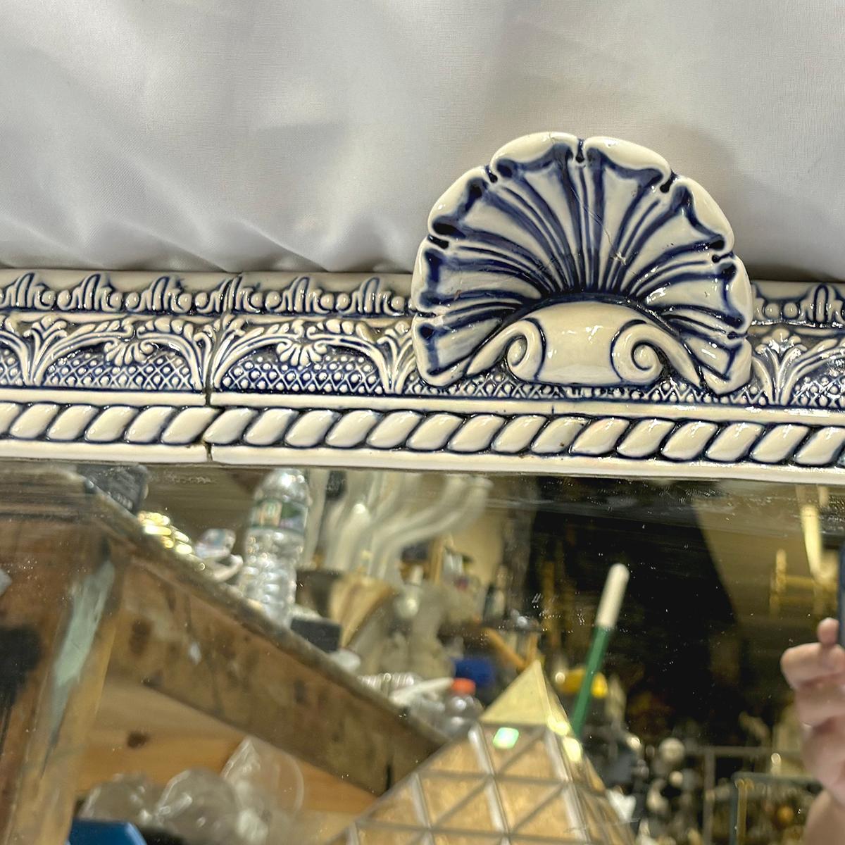 A circa 1900 English mirror with blue and white porcelain frame and shell motif. 

Measurements:
Height: 32.5