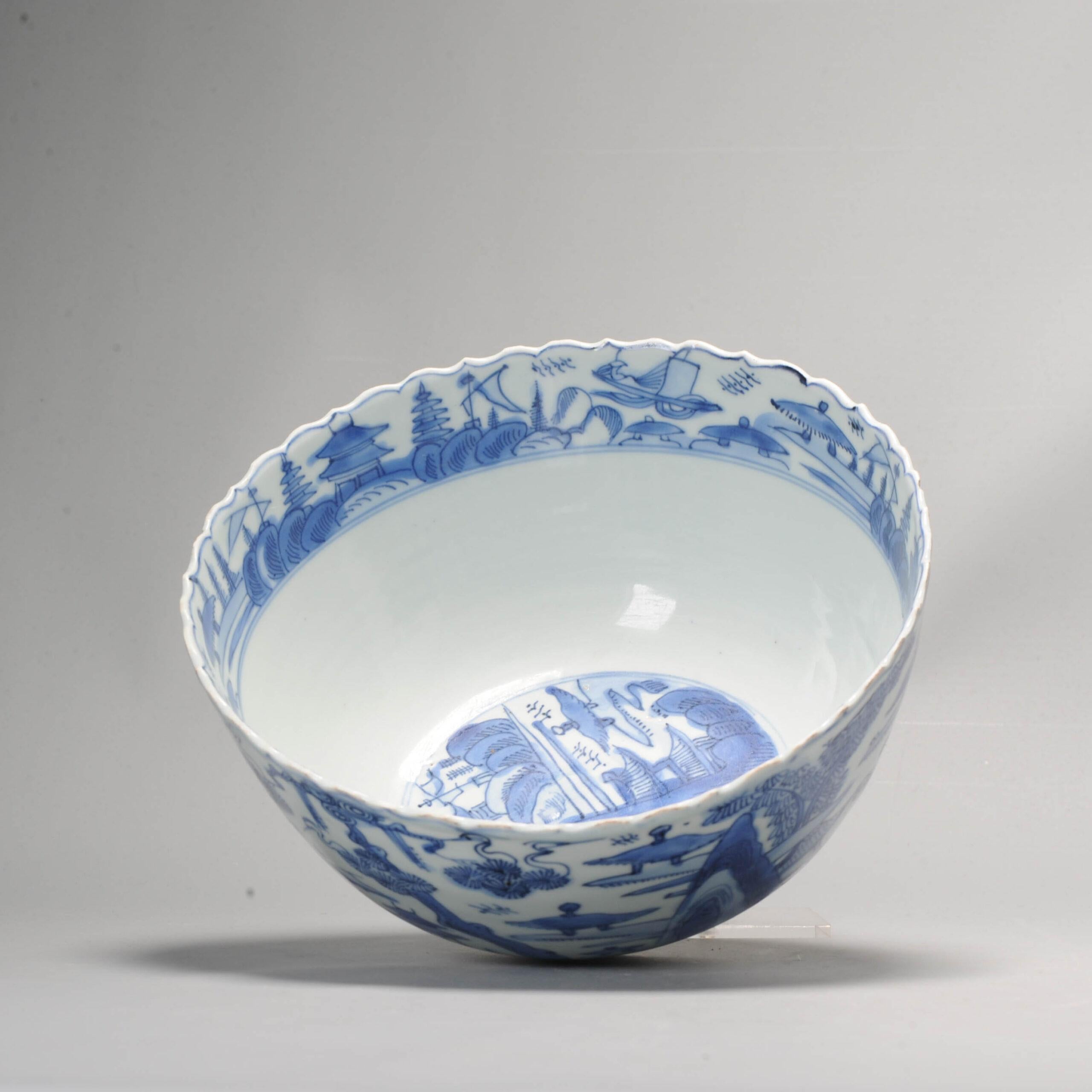 The large bowl with foliated rim from around 1600, Ming period. The bowl is decorated with a continuous river landscape scene with pagodas, pavilions, boats and cranes in a pine tree. The interior rim and interior central roundel are similarly