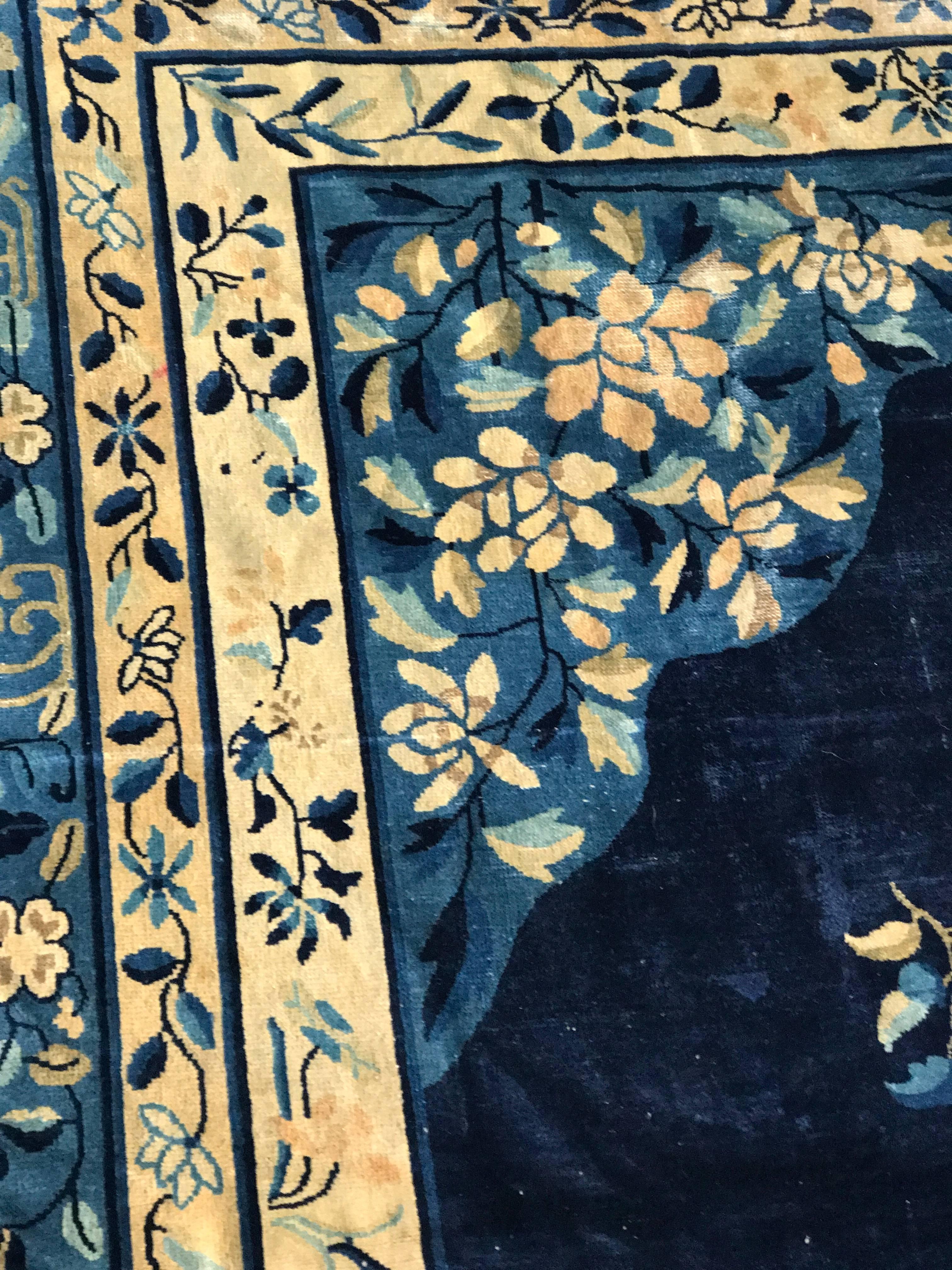 Ein feiner indigoblauer Peking-Teppich aus den frühen 1920er Jahren. Der Teppich hat ein traditionelles Peking-Design mit einem tiefblauen Hintergrund und einer beigen Umrandung. Es hat ein Medaillon in der Mitte und eine Blumenverzierung.