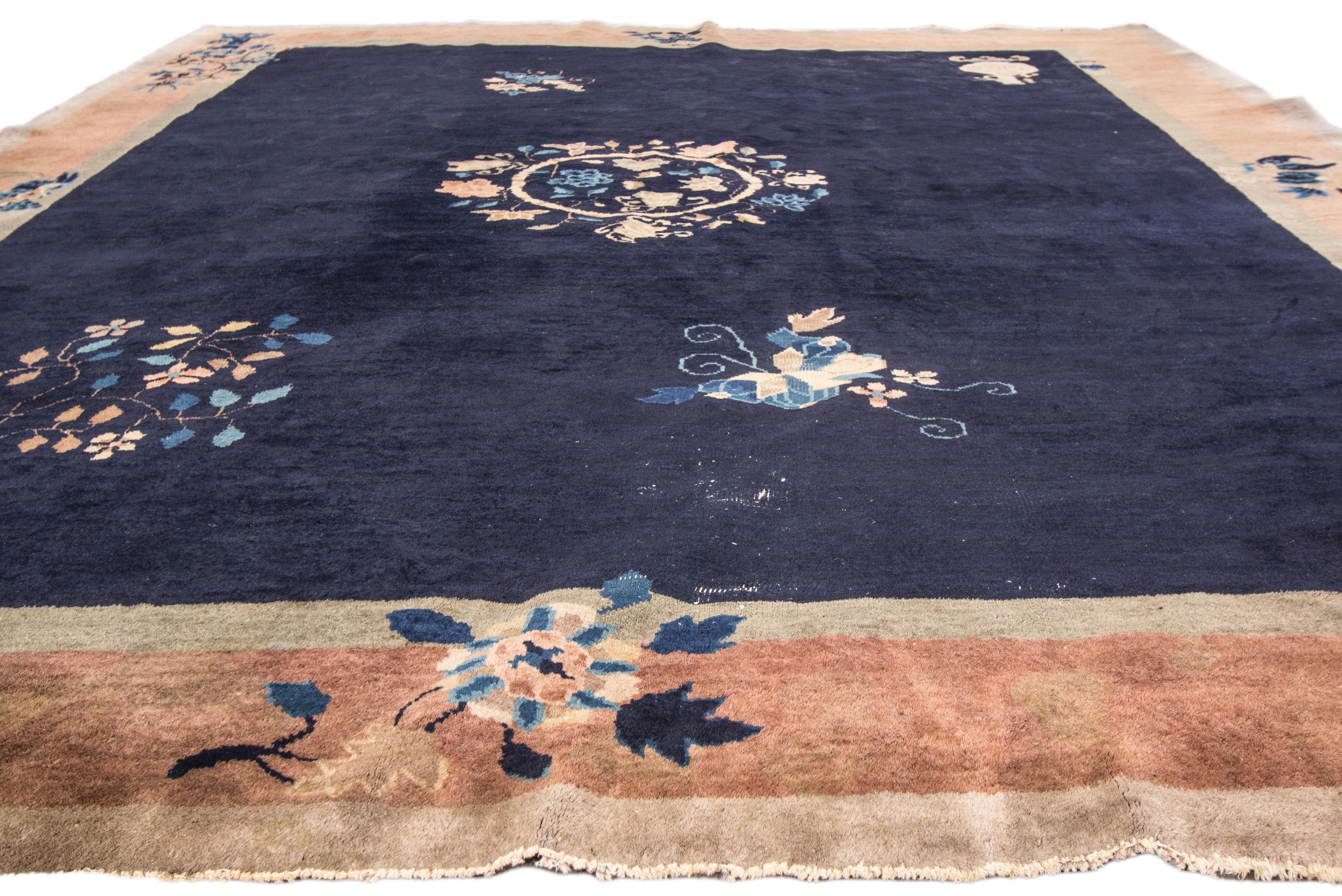 A hand-knotted antique Chinese rug with a all over design on a blue field. This rug measures 8'2
