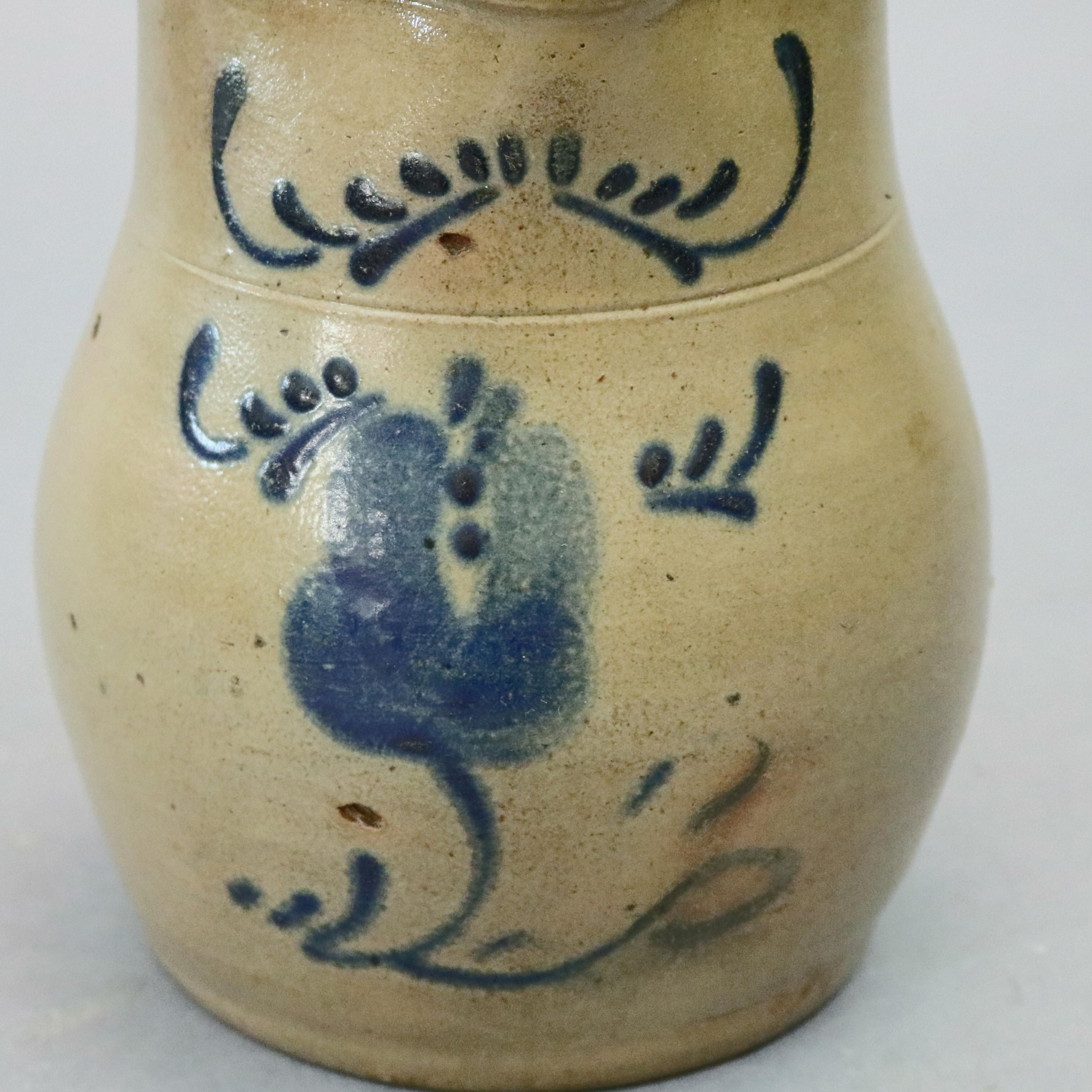 An antique primitive blue decorated batter jug offers stoneware construction in bulbous form with flared lip and spout and having floral motif, circa 1860

Measures: 8.5