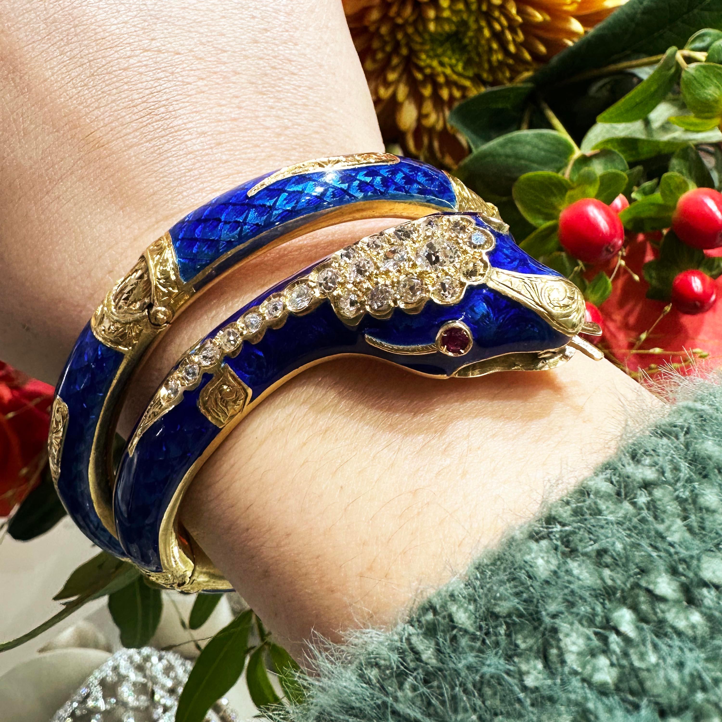 A Victorian snake bangle, with royal blue guilloché enamel, set with old-cut diamonds, in a cluster in the head and a line down the neck, with cabochon-cut ruby eyes, gold teeth and a moving tongue, with engraved gold foliate decoration on the nose,