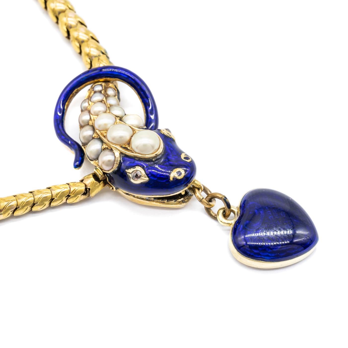 An antique snake necklace, with a gold scale link body and blue enamelled head, set with natural half pearls, with diamond eyes, with a blue enamel heart drop suspended from its mouth, with a locket back containing hair and a monogram. Length