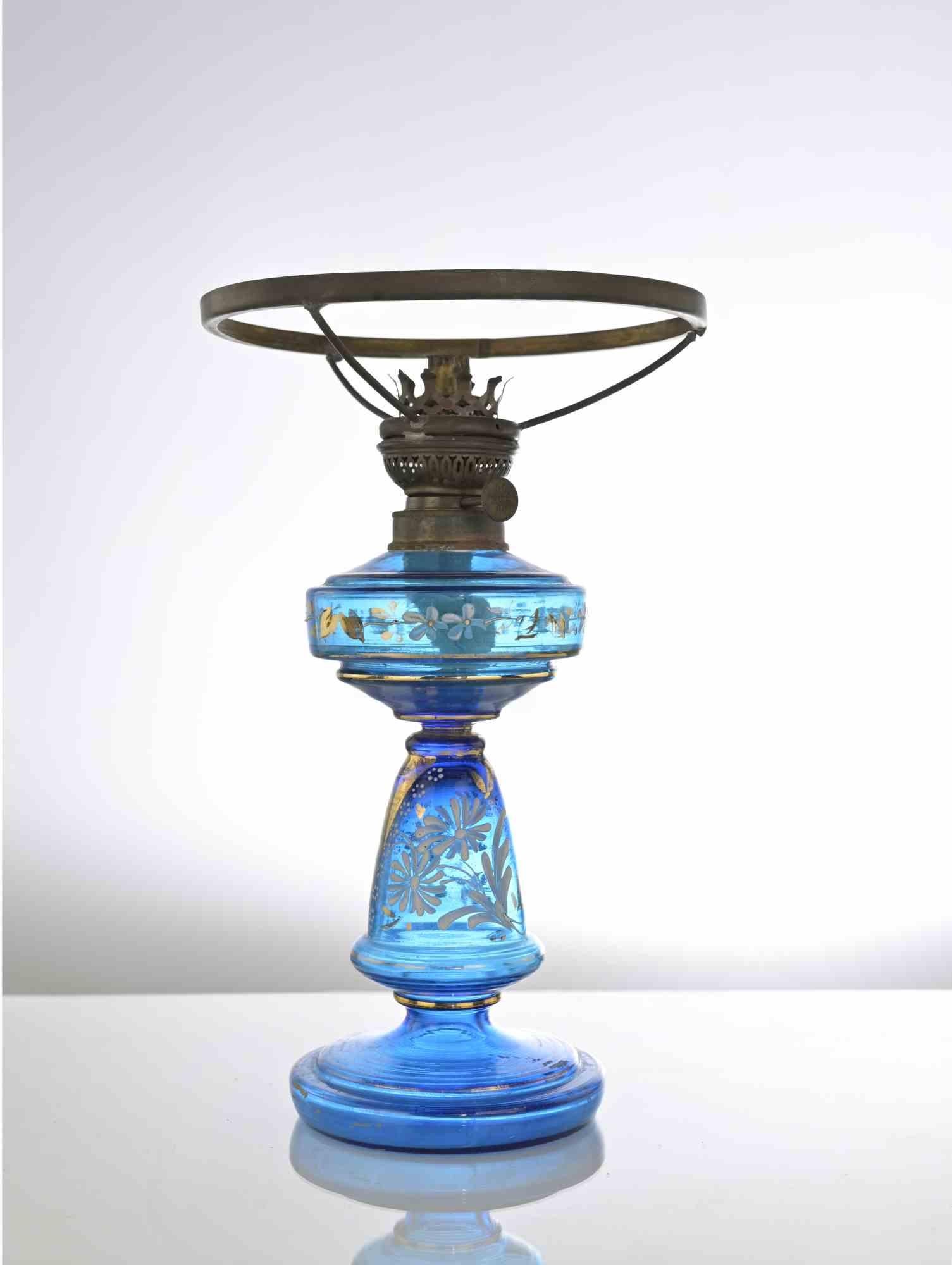Cette lampe à pétrole en verre bleu ancien est une lampe au design raffiné fabriquée vers 1910.

Lampe à huile en verre bleu avec décor floral en or et émail.

Dimensions : cm 50 x 23 (diamètre).

Bonnes conditions. 