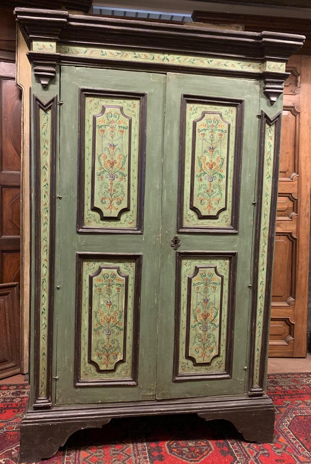Antique double door wardrobe, hand-carved and painted with a majority of blue / green colors, floral motifs typical of the time, built in the middle of the 1700s by an artisan artist in Italy.
In excellent condition, versatile and suitable for many