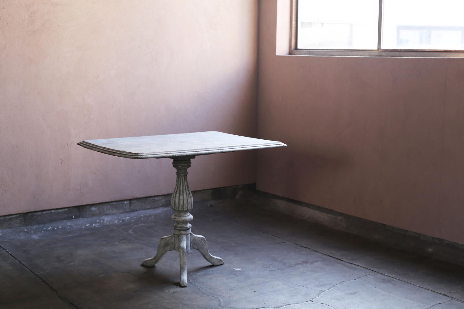 Questo tavolo francese del XIX secolo con piedistallo inclinabile è caratterizzato da un piano quadrato che può essere ripiegato in verticale, rendendolo pratico e facile da riporre in spazi limitati. La gamba centrale e la base a treppiede,