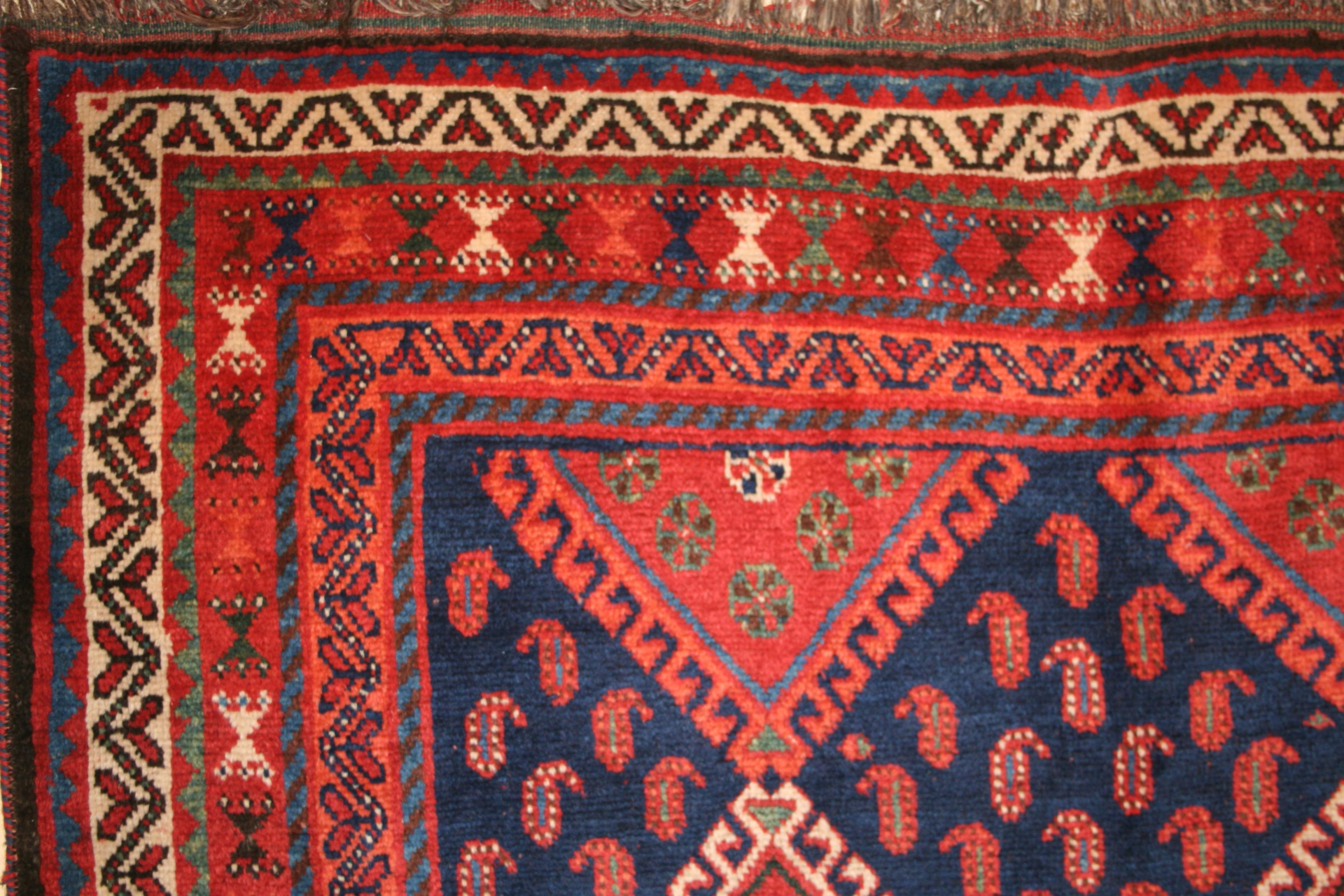Una hermosa alfombra kurda antigua del sur del Cáucaso, que se distingue por su gama de tintes naturales, que incluye un rico fondo azul añil, adornado por tonalidades joya de blanco, rojo, albaricoque y verde azulado. El motivo central se compone